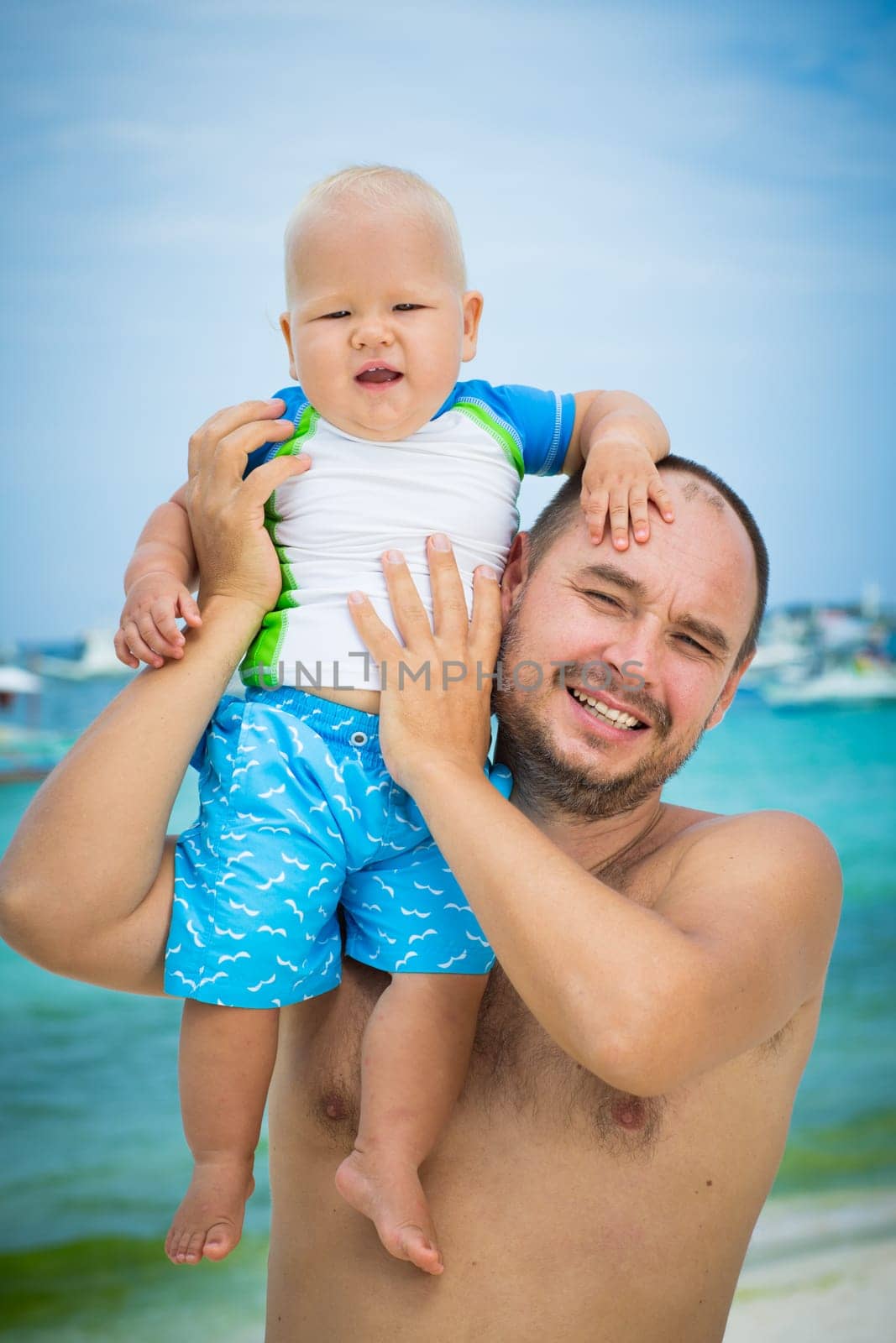 Baby and father on the tropical beach
