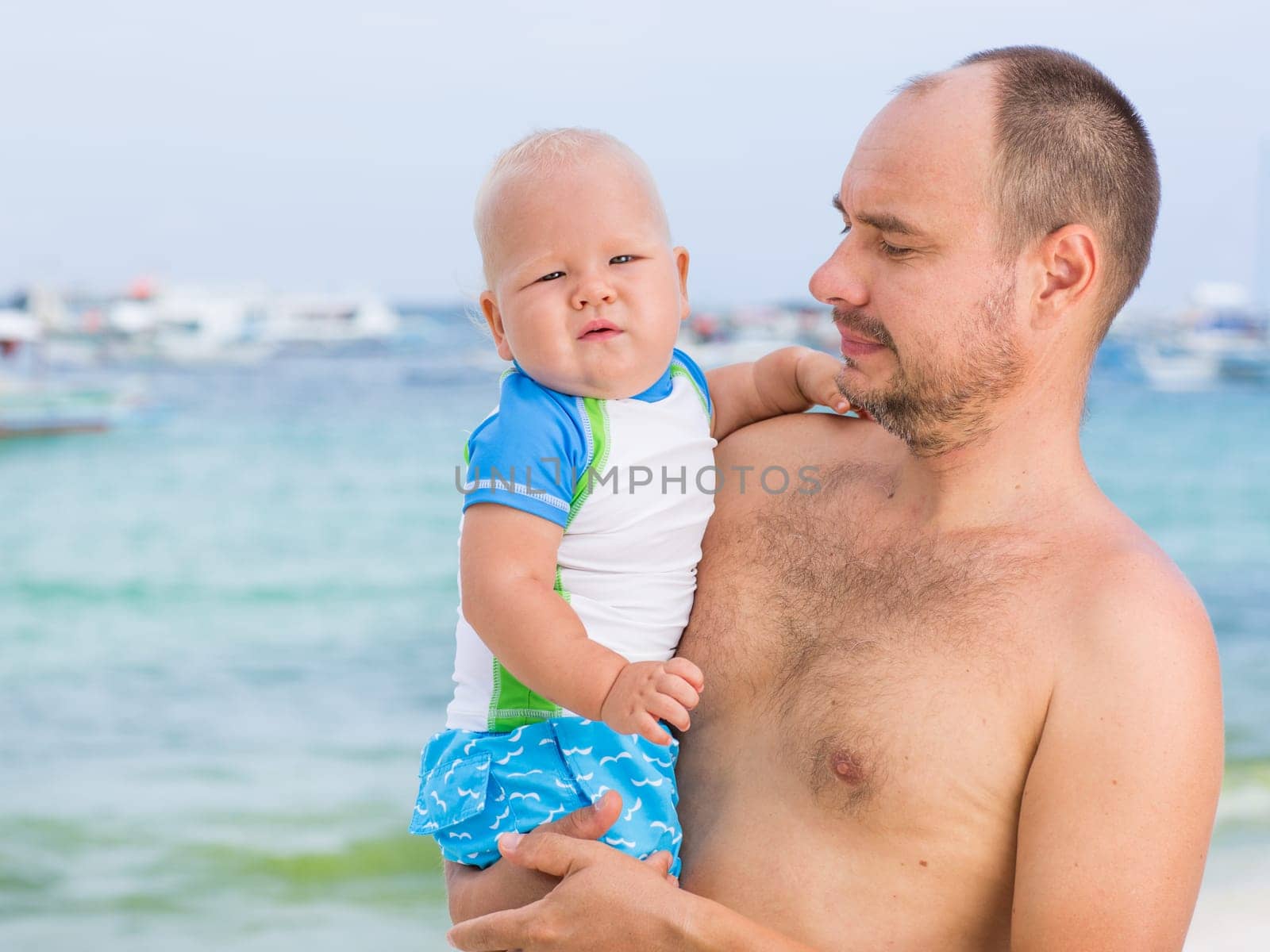 Baby and father on the tropical beach