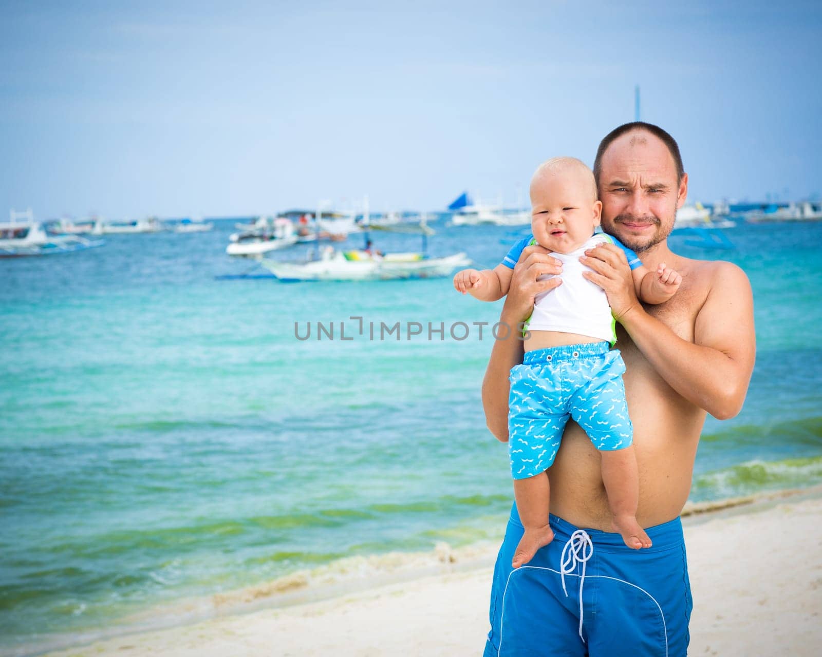 Baby and father on the tropical beach