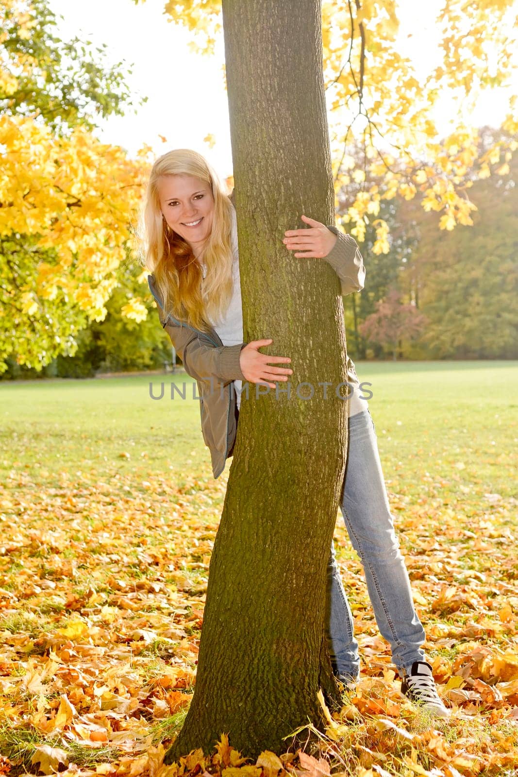 young woman hugs tree