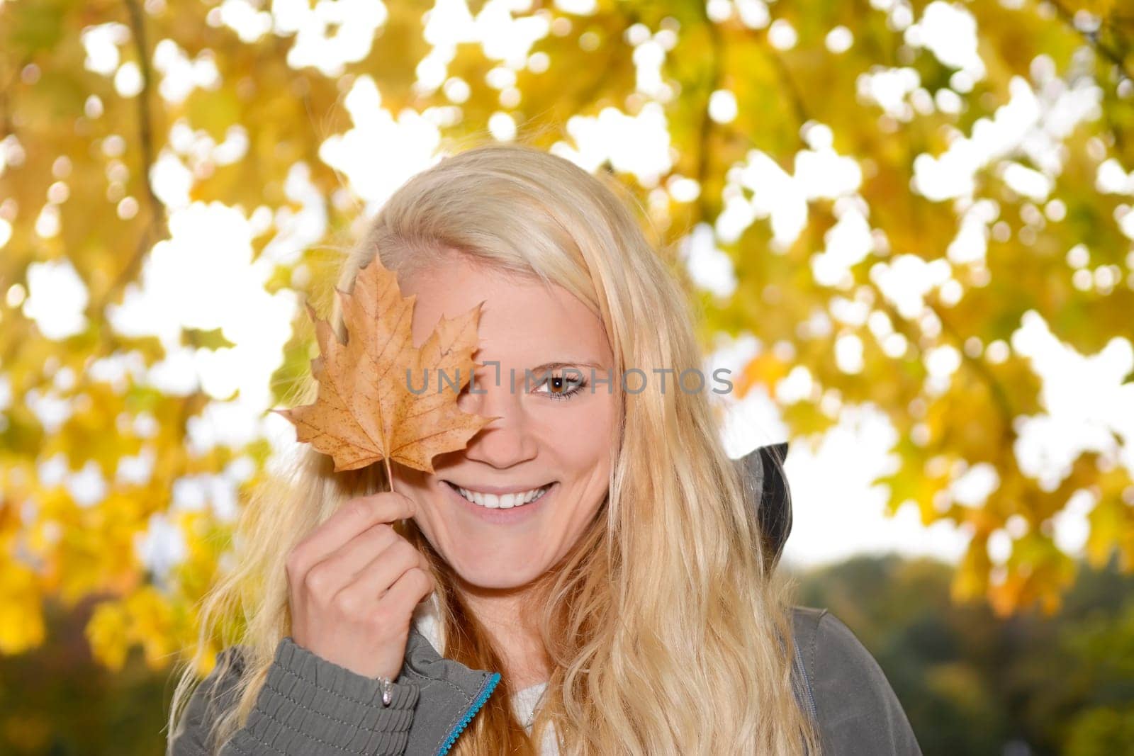 young woman with autumn leaf