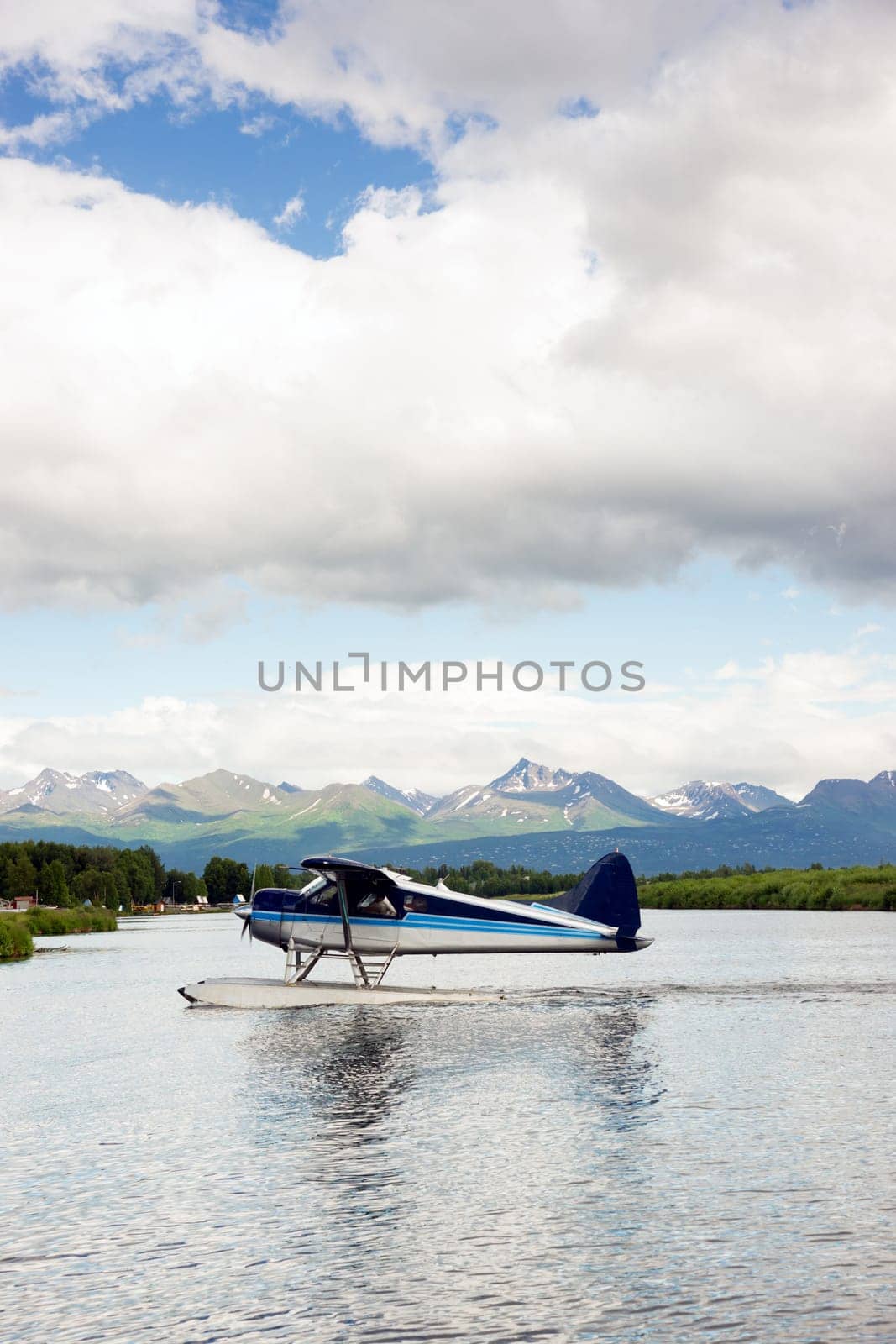 A bush plane performs take off/landing in Alaska with Chugach Mountains in the Background