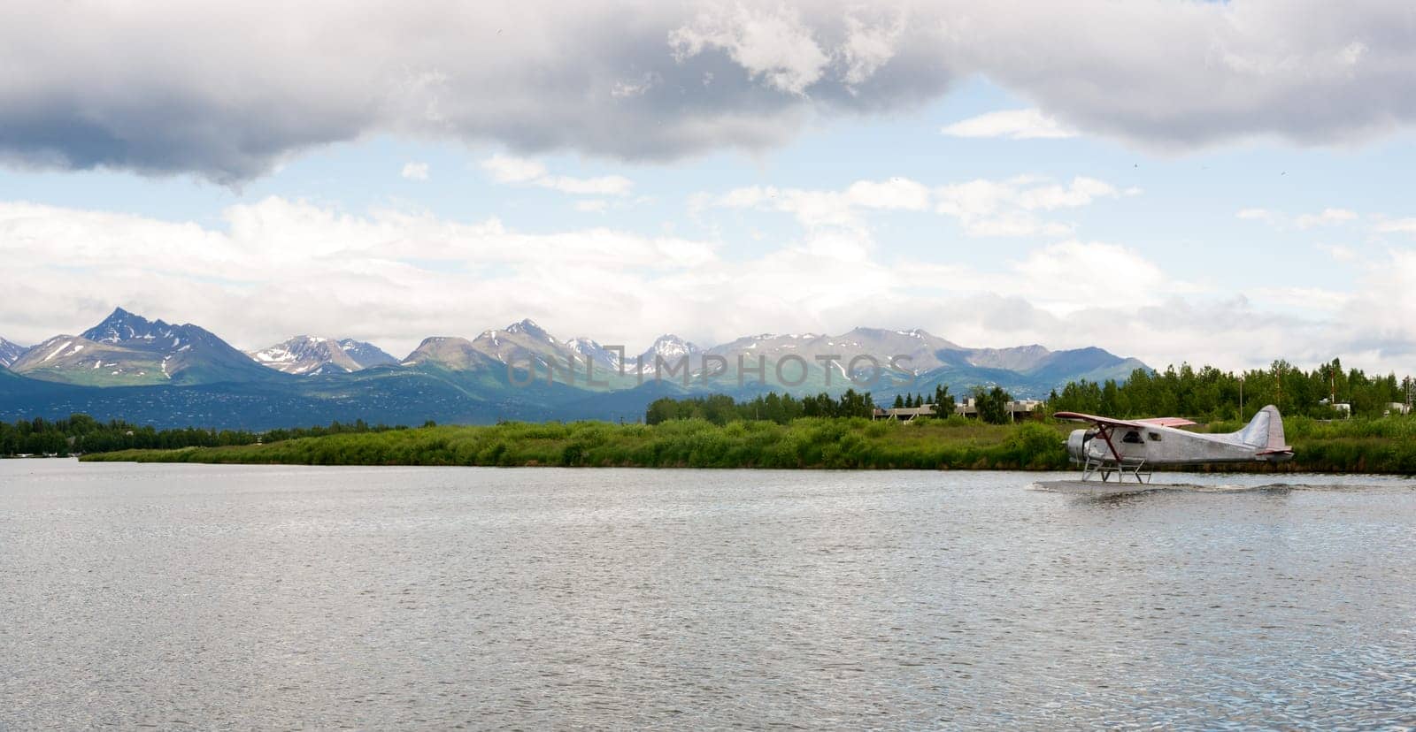 A bush plane performs take off/landing in Alaska with Chugach Mountains in the Background