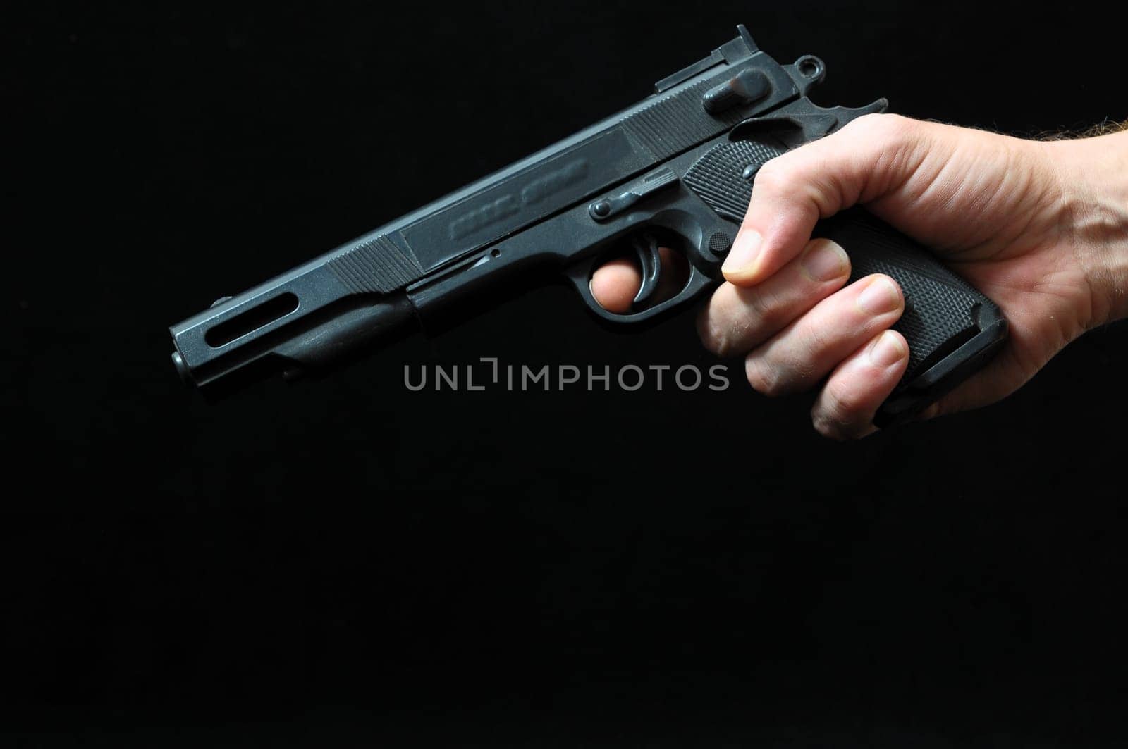 Gun and a Hand on a Black Background