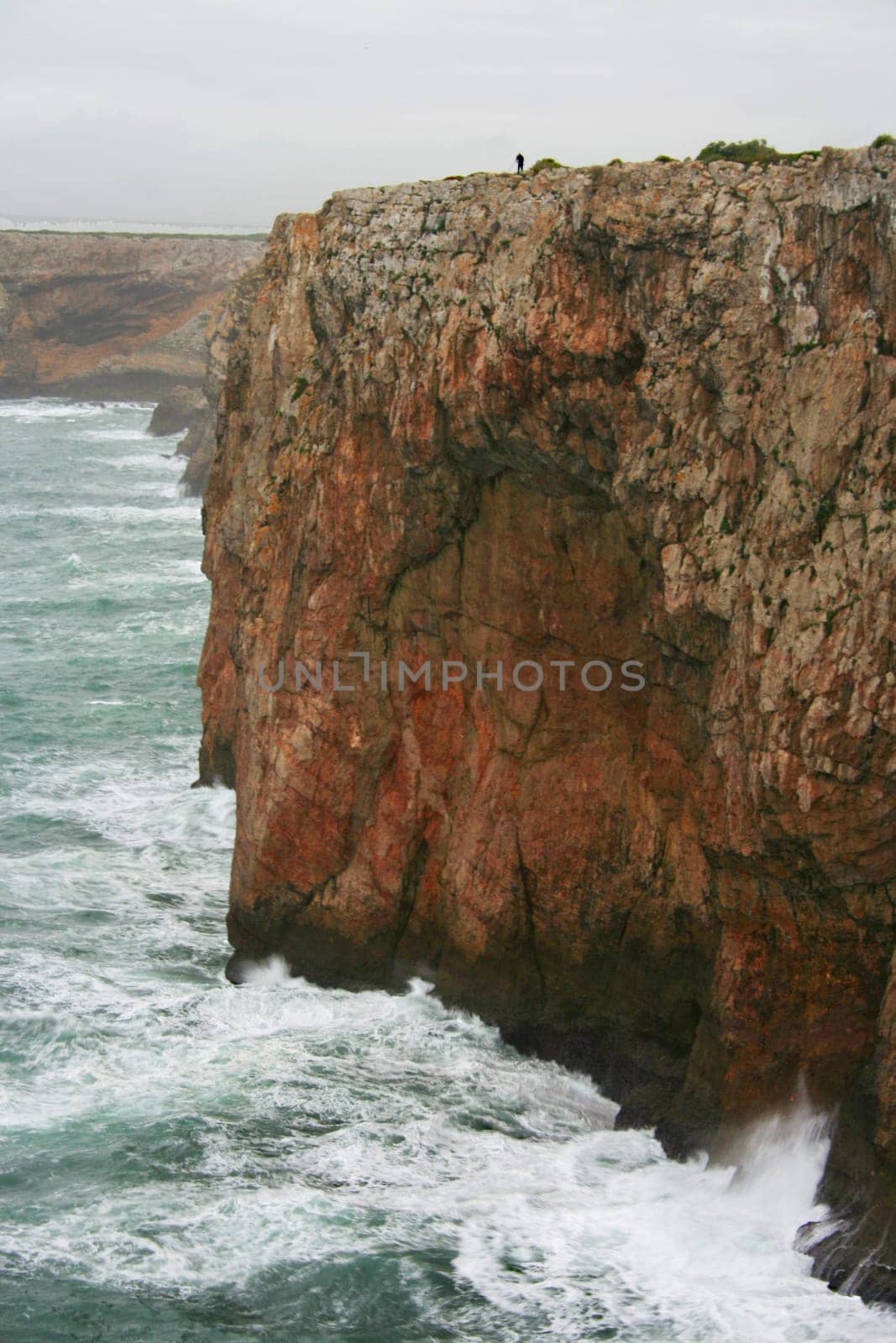 Severe dramatic seascape with fisherman in Cape Saint Vicent cliffs, Porrtugal