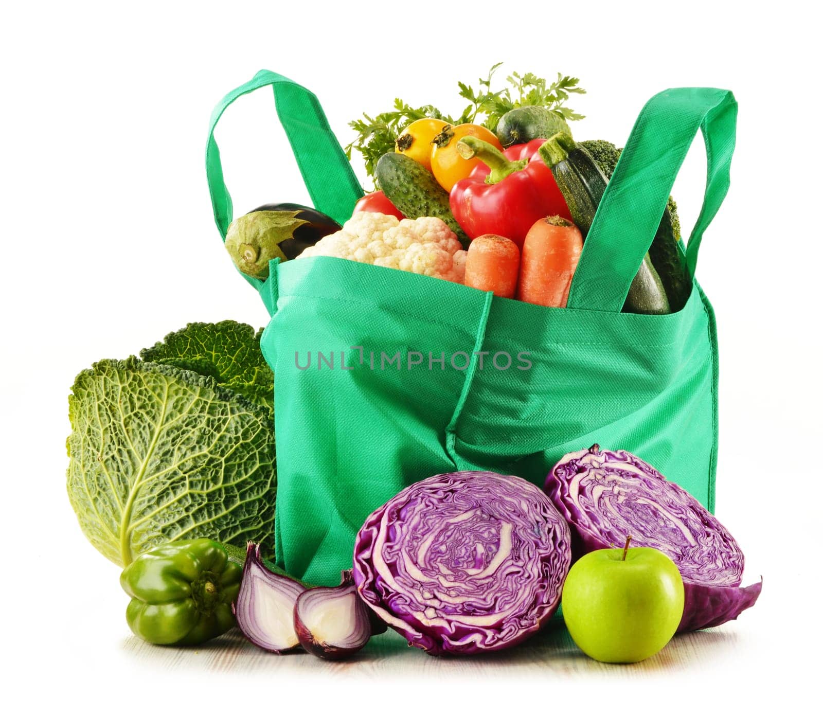 Shopping bag with variety of fresh organic vegetables isolated on white