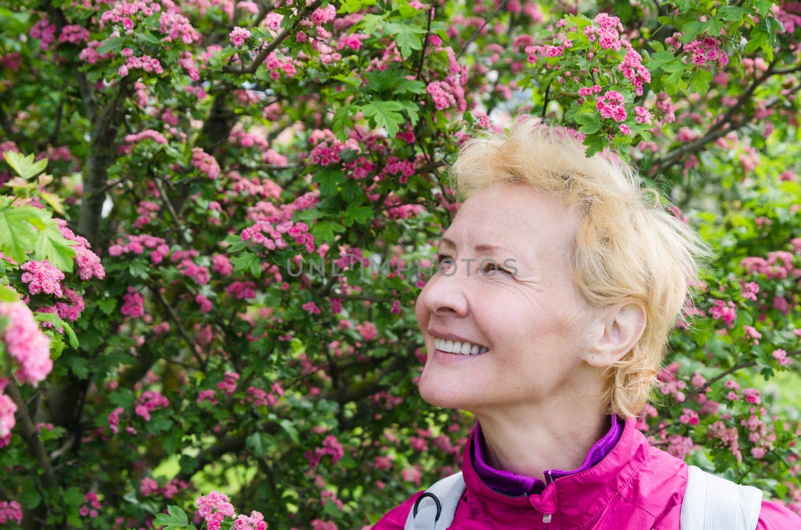 Portrait of a woman in a blossoming hawthorn