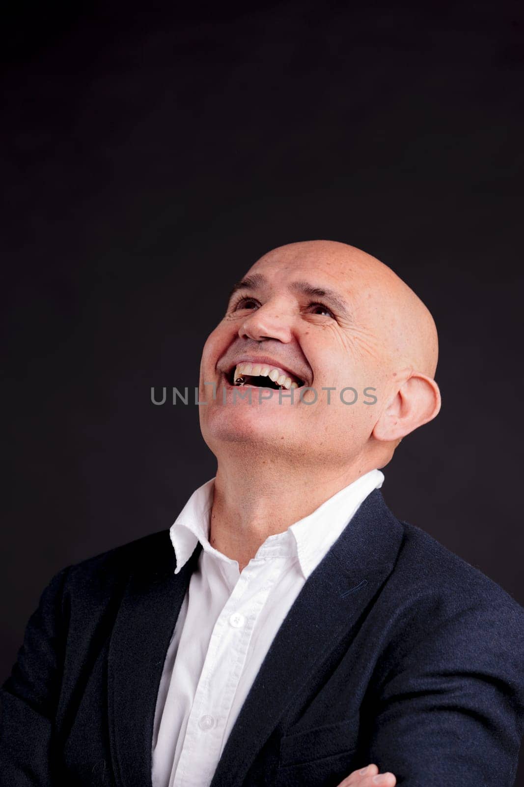 old bald self-confident businessman on a dark background