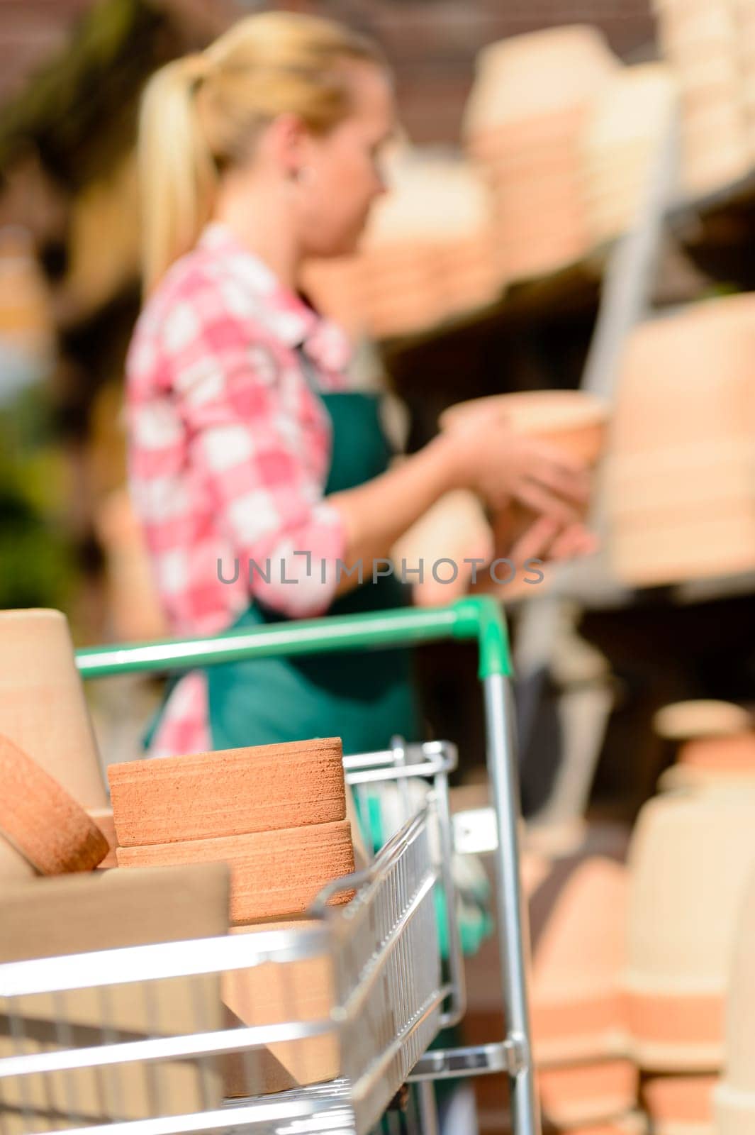 Close-up of shopping cart with clay pots garden center woman