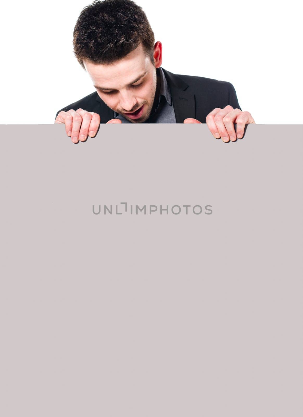 Portrait of young man in business suit looking down at blank sign, Isolated on white.