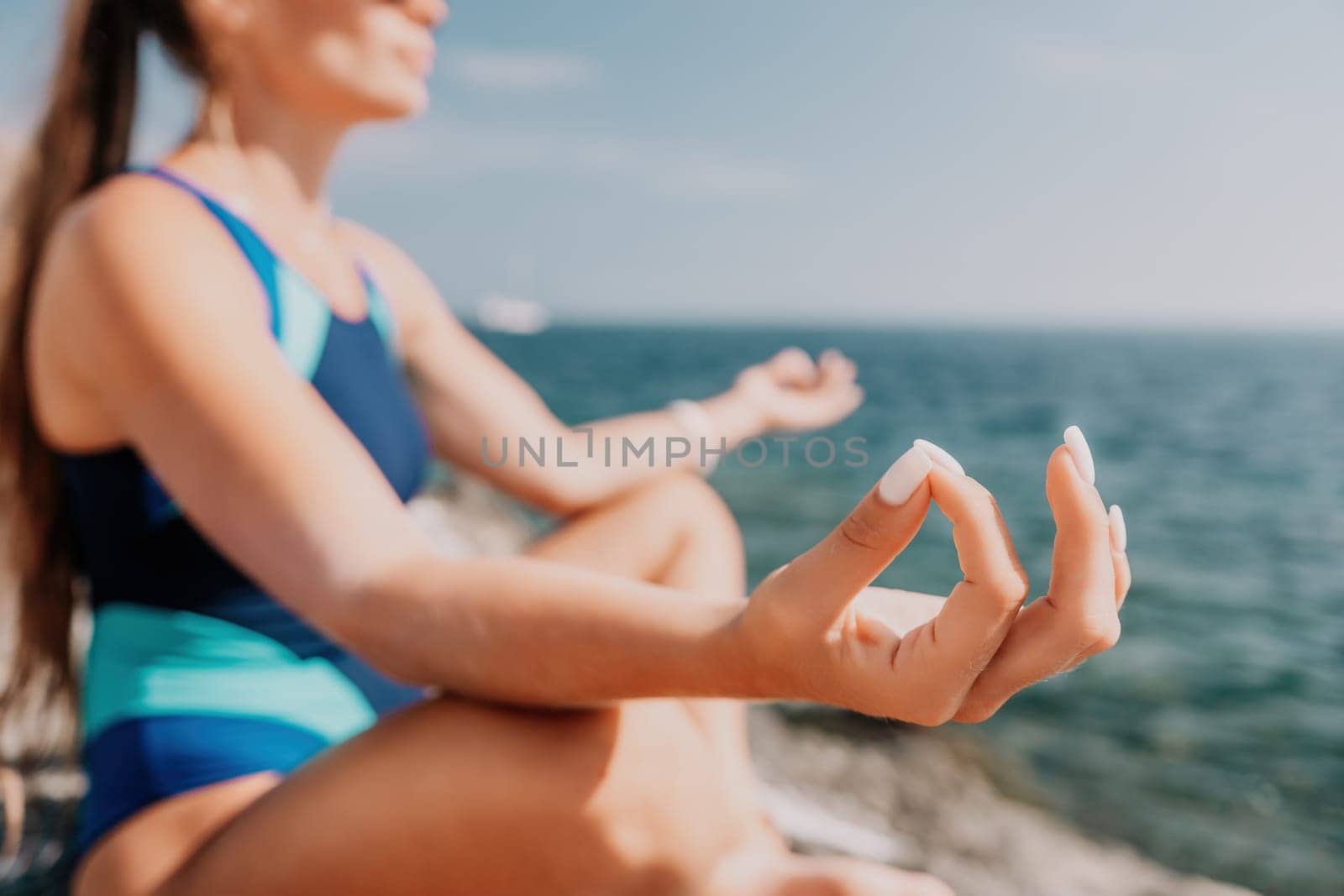 Woman sea yoga. Happy woman meditating in yoga pose on the beach, ocean and rock mountains. Motivation and inspirational fit and exercising. Healthy lifestyle outdoors in nature, fitness concept. by panophotograph