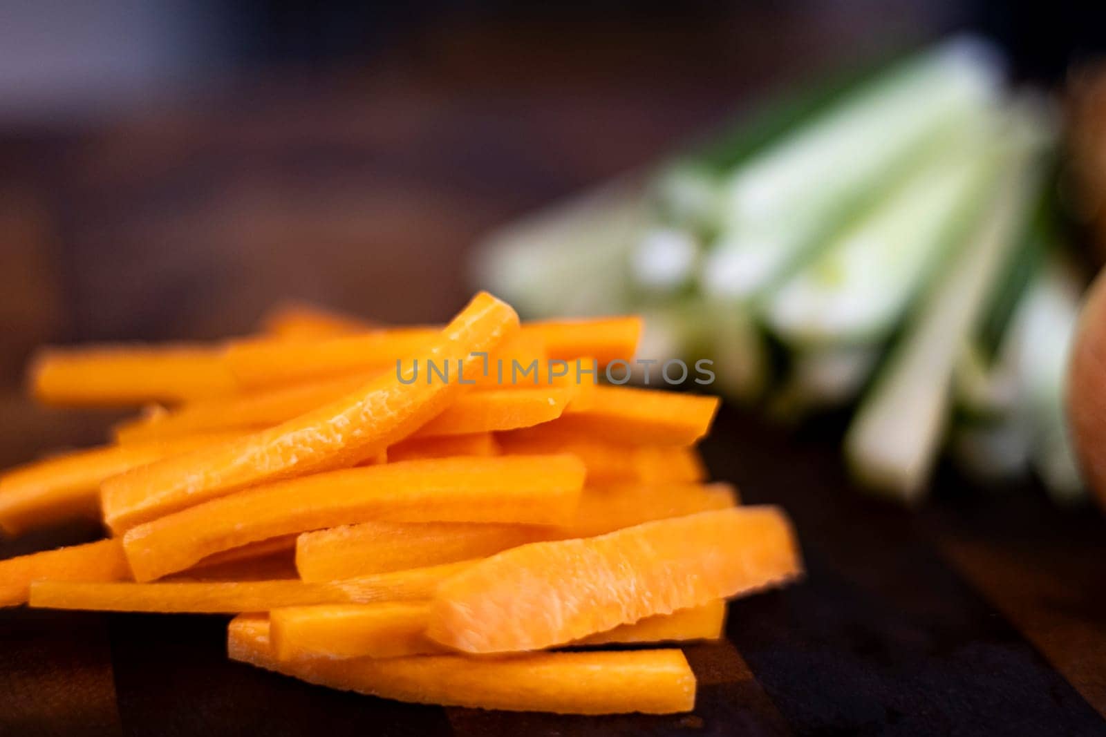 Chopped carrot on wooden board selective focus. Julienne Carrots On The Food Preparation Table.