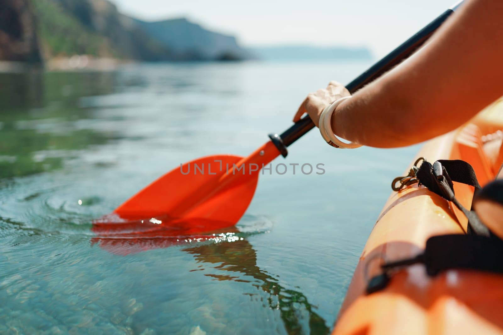 Kayak paddle sea vacation. Person paddles with orange paddle oar on kayak in sea. Leisure active lifestyle recreation activity rest tourism travel by Matiunina