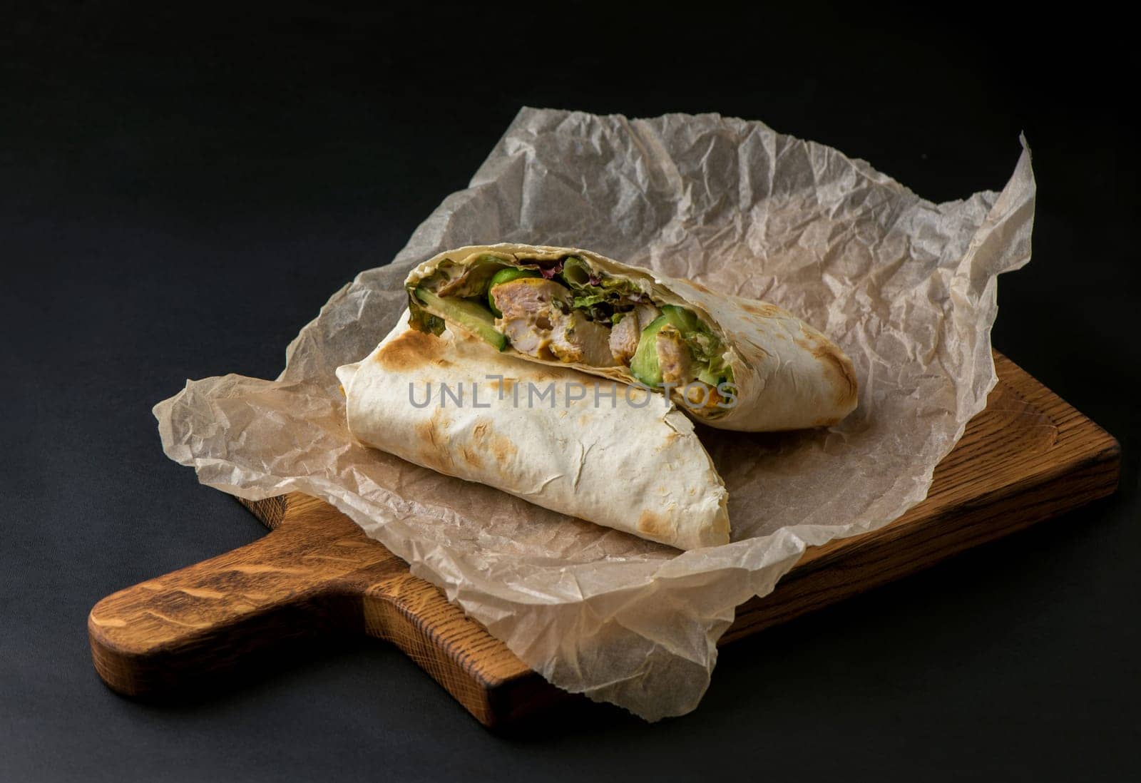 pita bread with meat, herbs and tomatoes on a dark