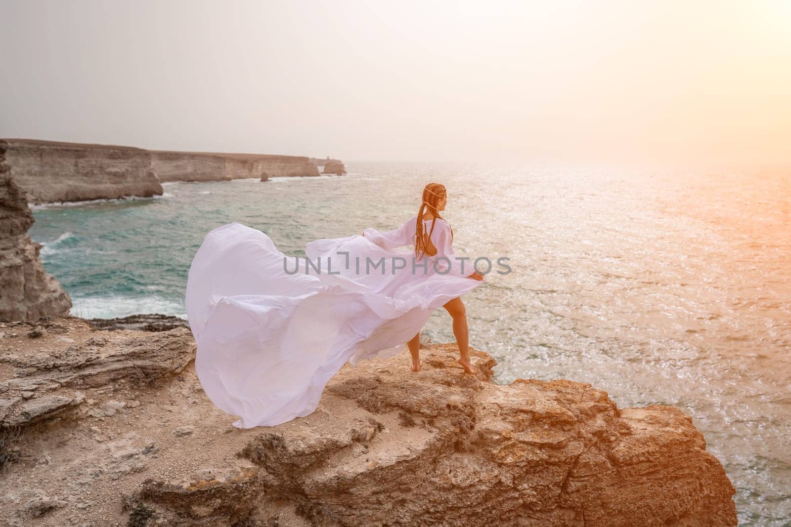 Woman sea white dress. Happy freedom woman on the beach enjoying and posing in white dress. Rear view of a girl in a fluttering white dress in the wind. Holidays, holidays at sea. by Matiunina