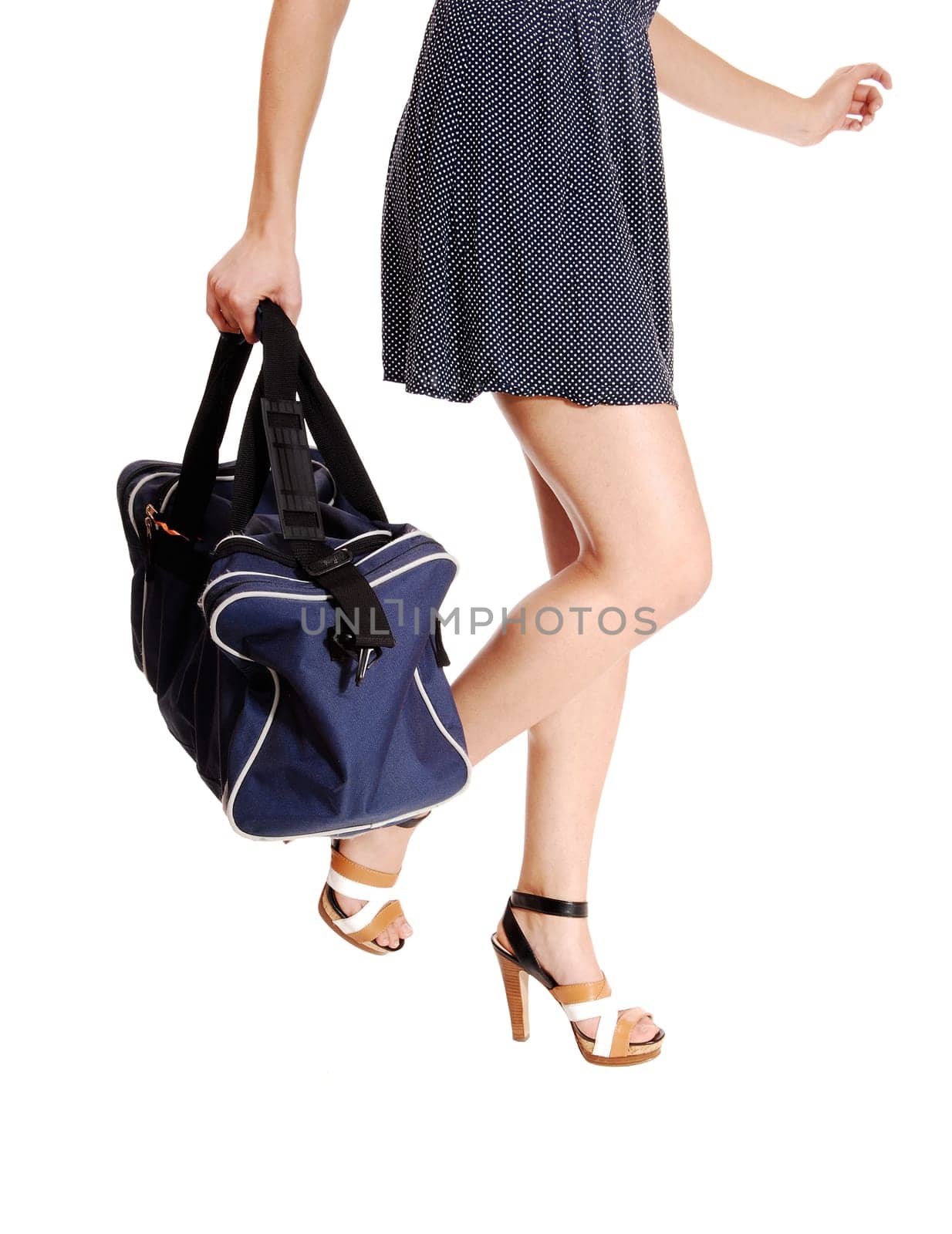 A closeup picture of young woman's legs holding a big bag in her hands,.isolated on white background..