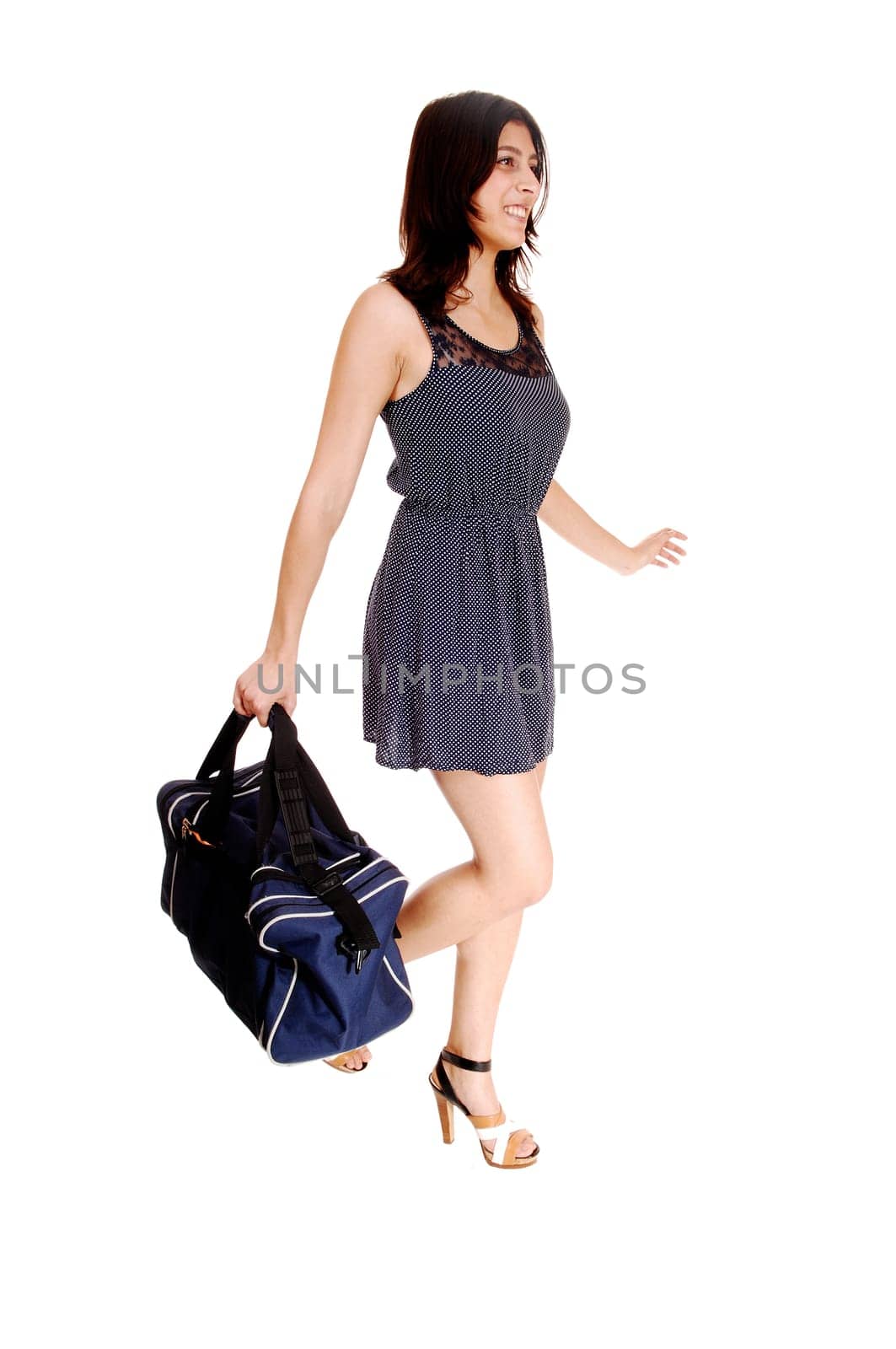 A young woman in a grey dress carrying a big bag in her hand, isolated.on white background..