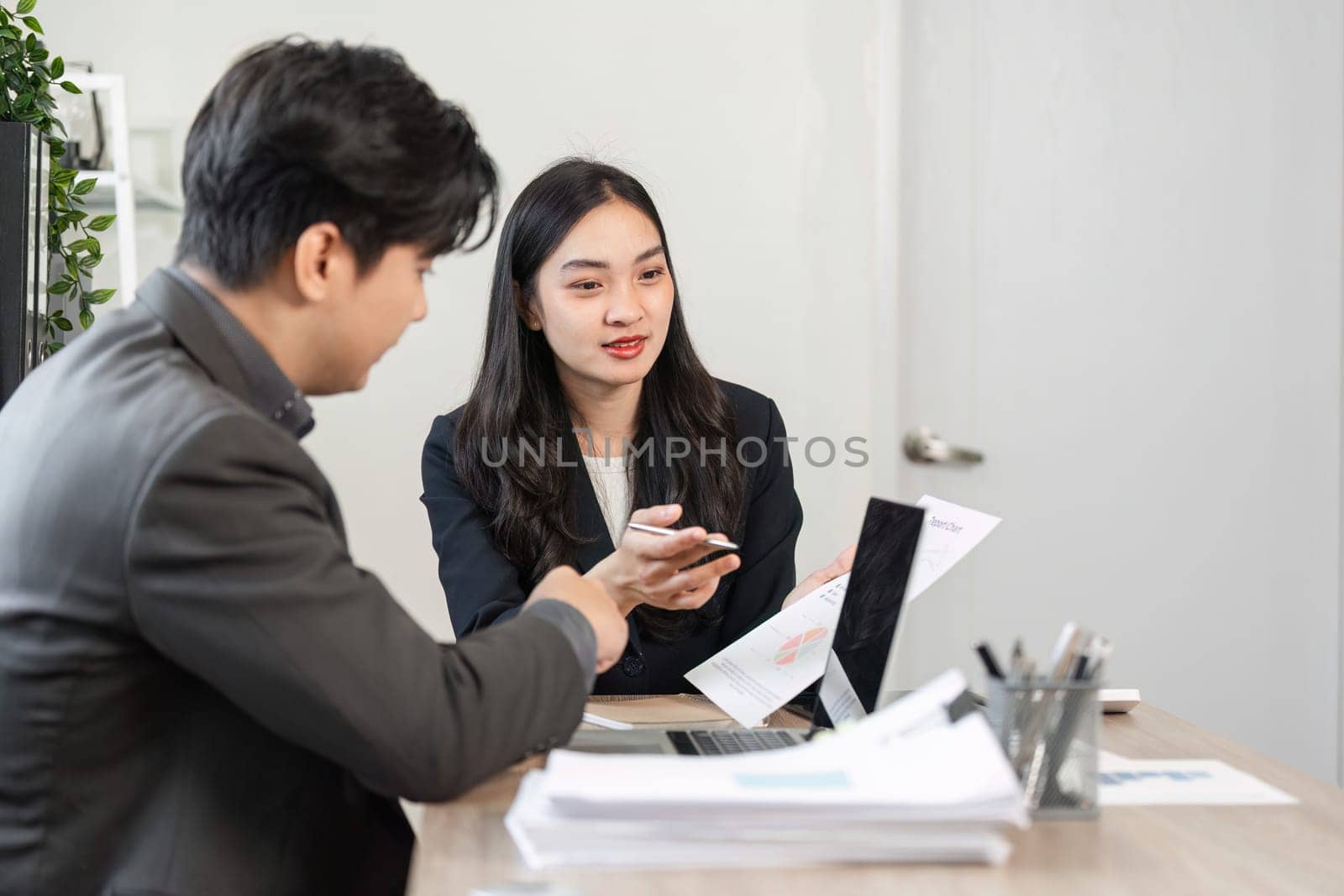 Two business professionals engage in a discussion about financial reports and strategies, emphasizing collaboration and analysis.