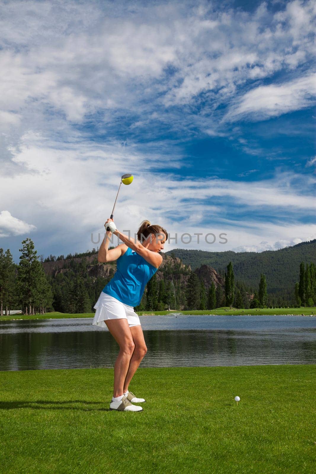 Outdoor photo of attractive woman golfing.