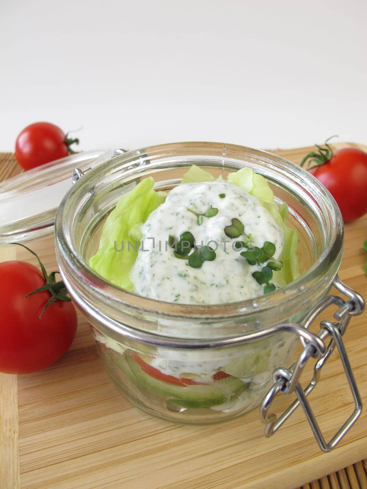 Salad in glass with yoghurt dressing and broccoli sprouts