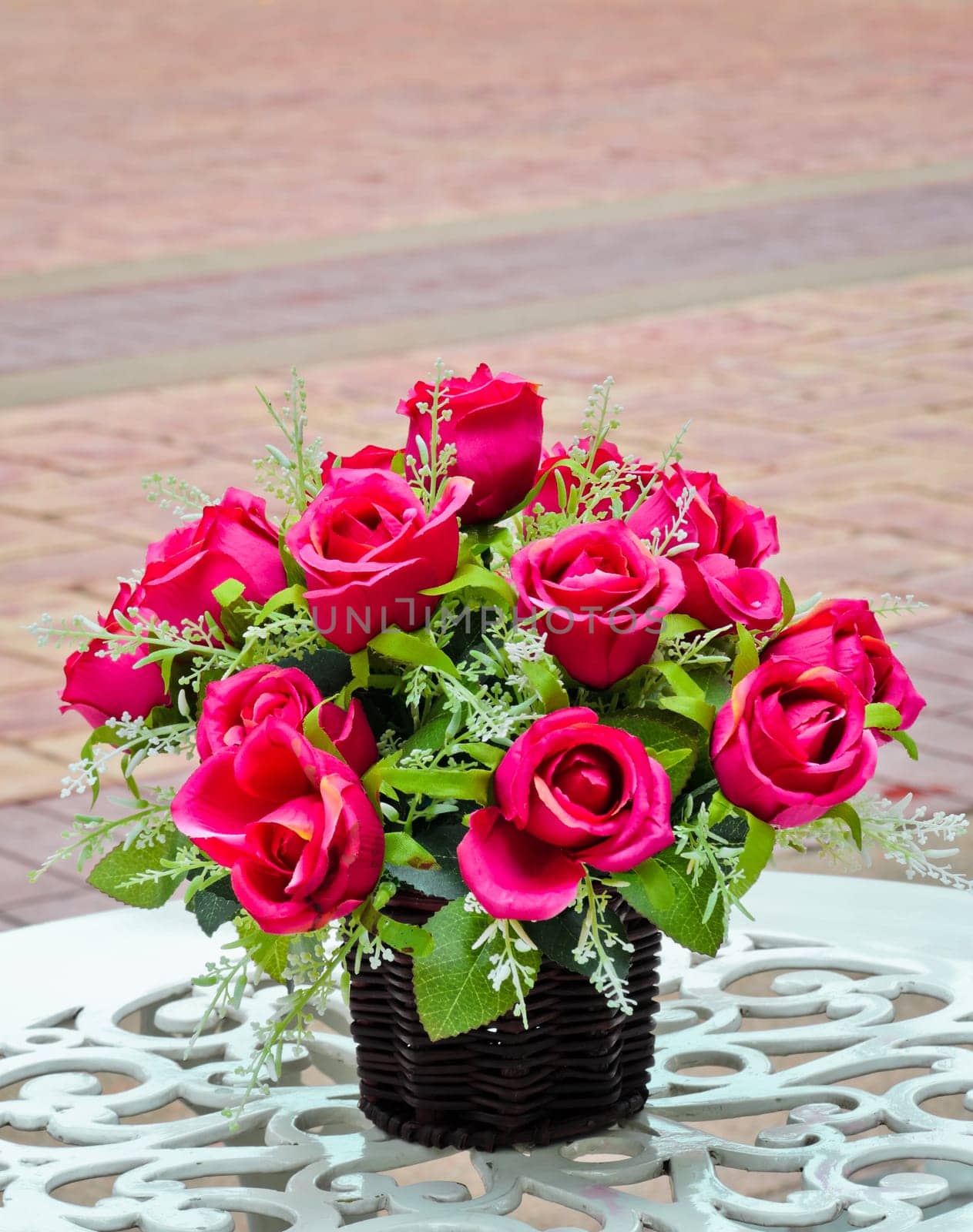 Artificial rose flower on white table
