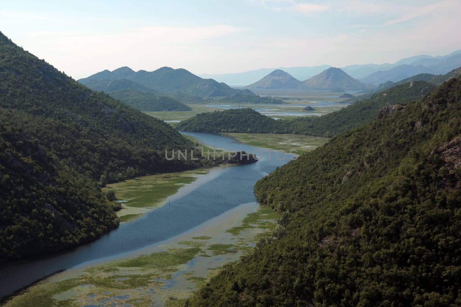 The landscape at Rijeka Crnojevica with the river Rijeka Crnojevica at the western end of the Skadarsko Jezero lake or Skadar lake in Central Montenegro in Montenegro in the Balkans on the Mediterranean Sea in Europe.