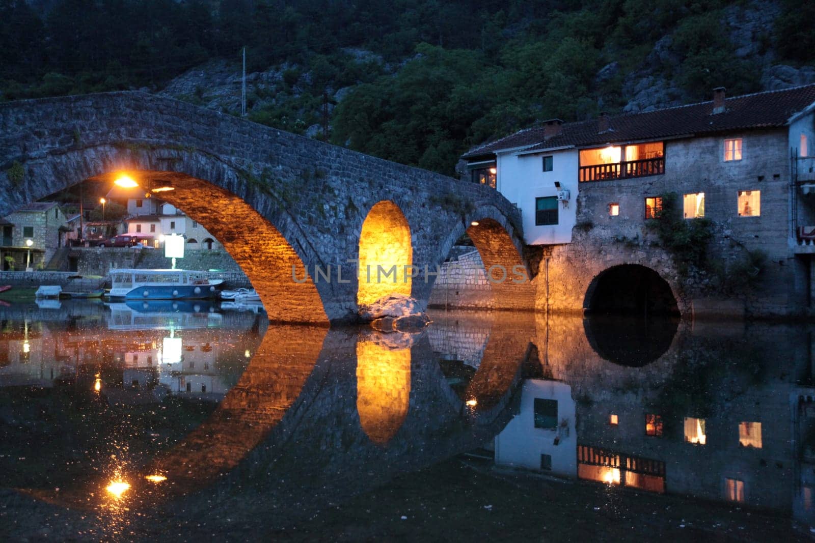 The landscape with the stone bridge of Rijeka Crnojevica with the river Rijeka Crnojevica at the western end of the Skadarsko Jezero lake or Skadar lake in Central Montenegro in Montenegro in the Balkans on the Mediterranean Sea in Europe.