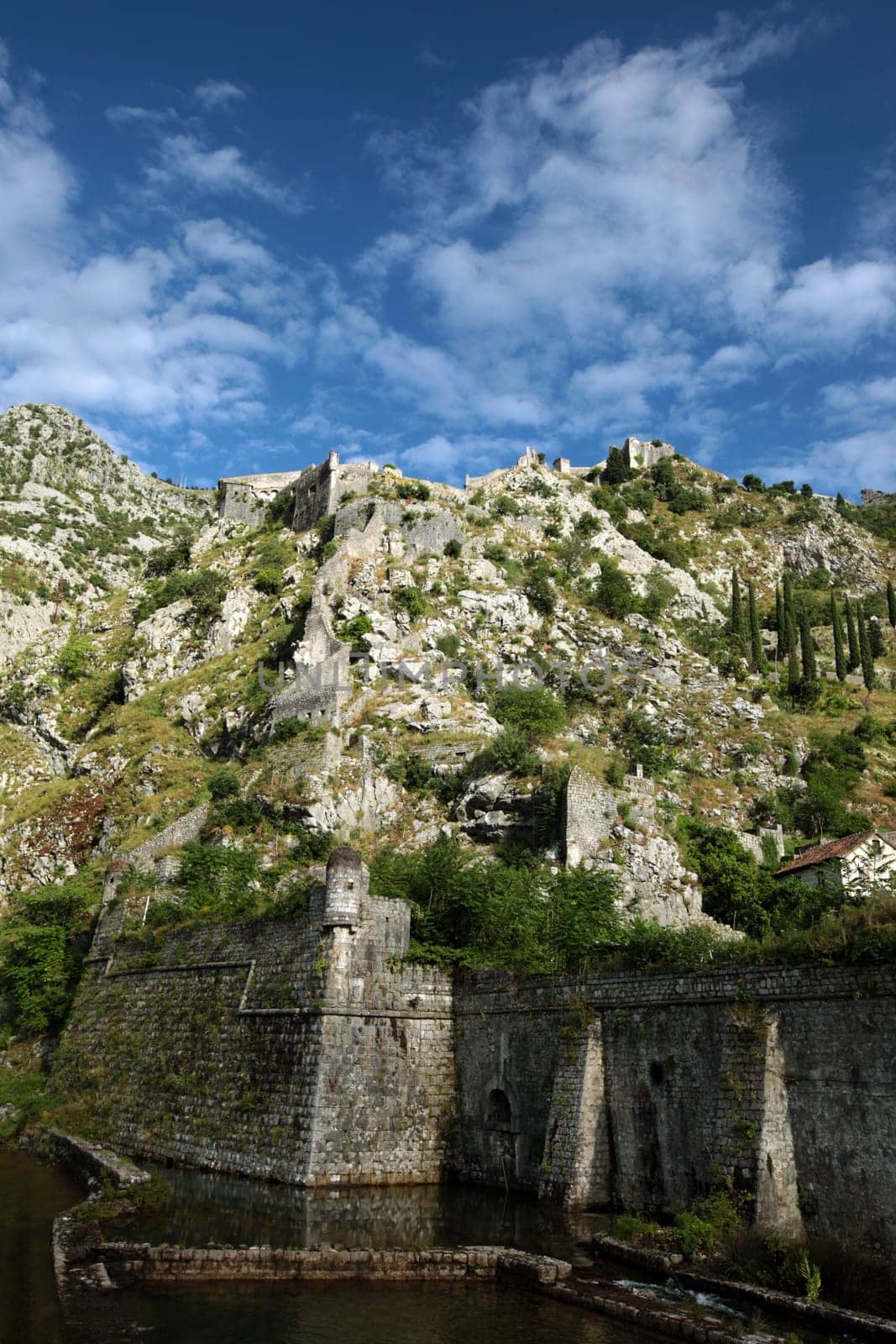 The mountain landscape with the city wall of Kotor in the inner bay of Kotor on the Mediterranean Sea in Montenegro in Europe.