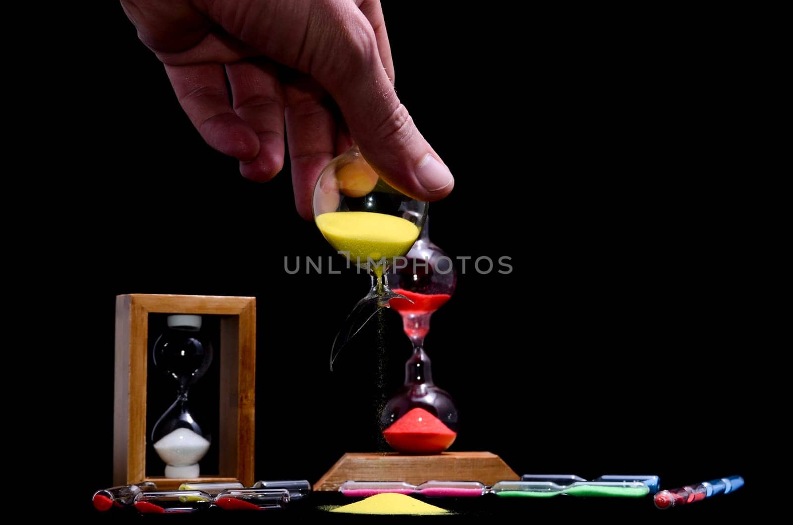 Deadline Concept Broken Hourglass with Yellow Sand on Black Background