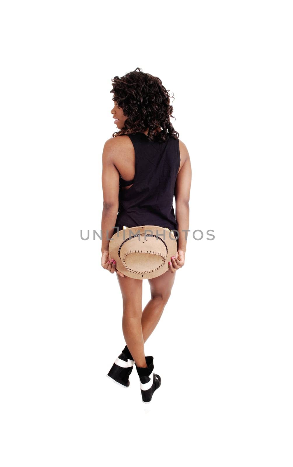 A pretty Jamaican woman in exercise outfit standing from the back.holding a hat on her butt, isolated for white background..