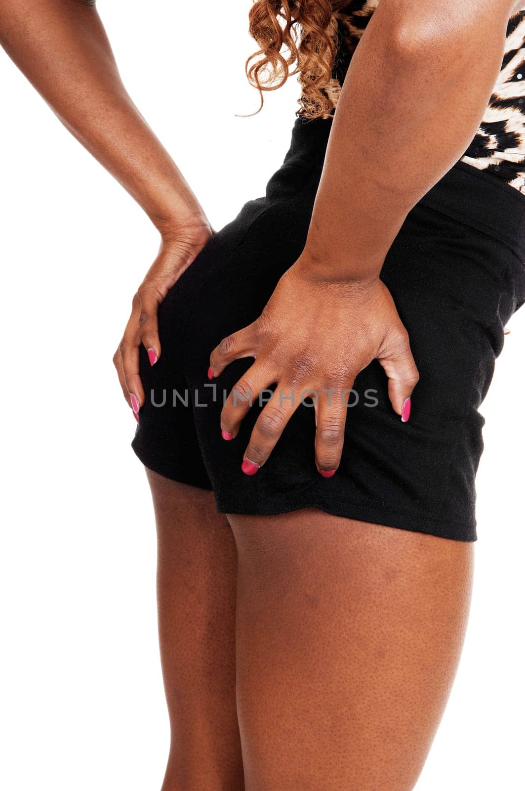 A closeup picture of the bottom and legs of a young Jamaican woman.holding her butt, isolated for white background..