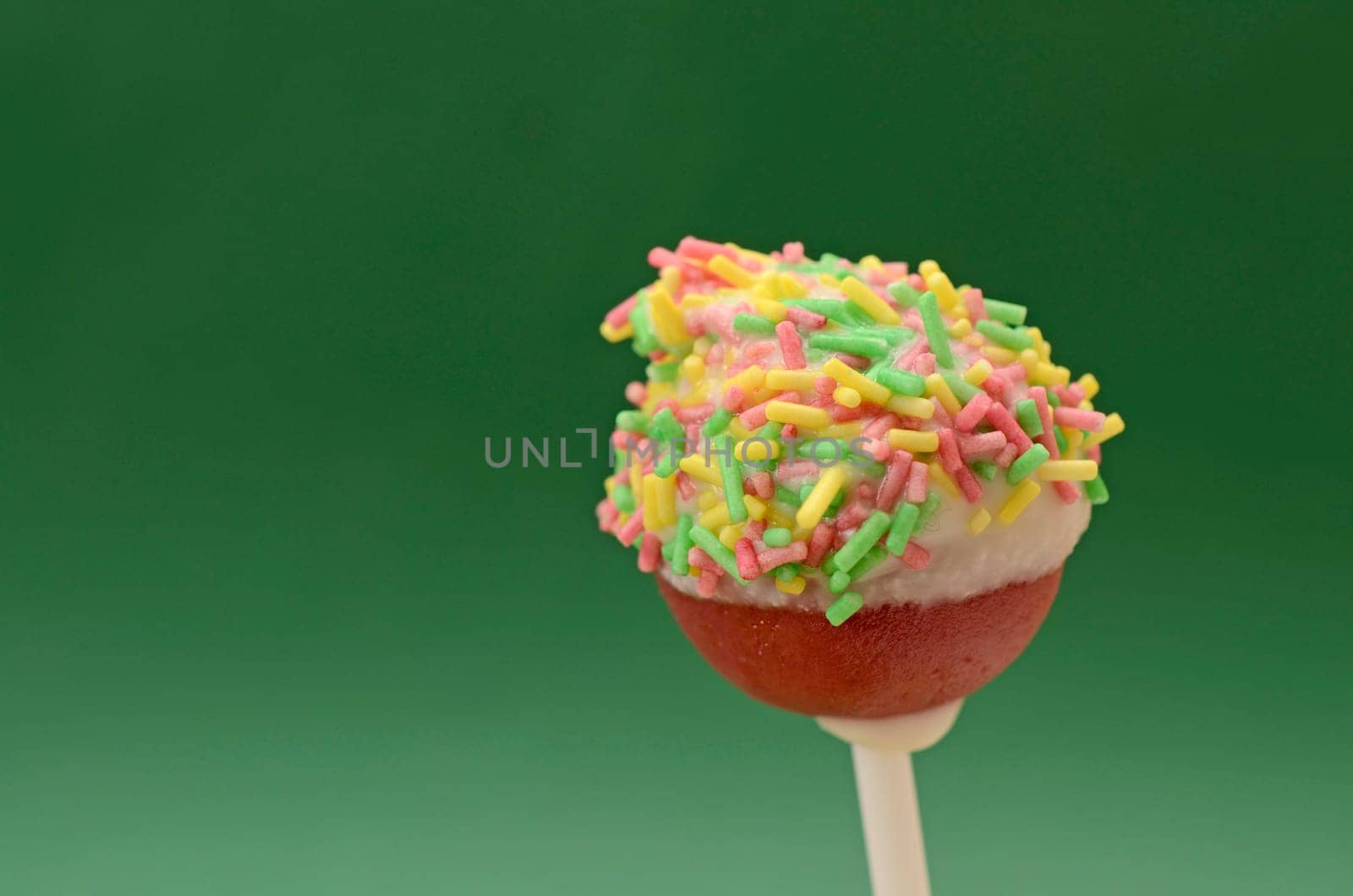 Cake pop with sugar pearls on a green background