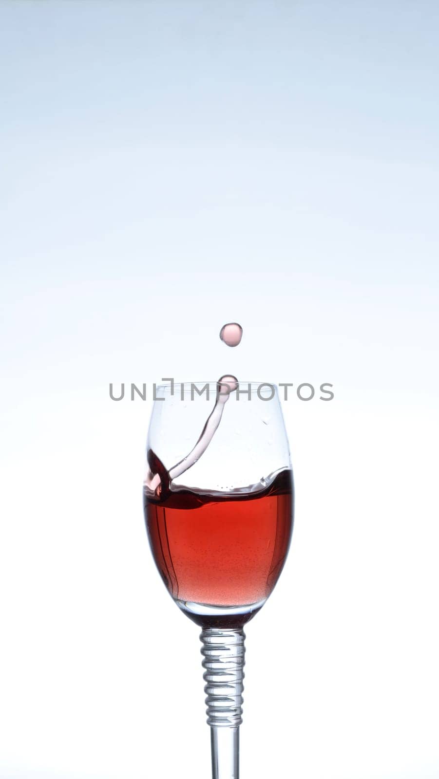 Splashing red wine on a blue background
