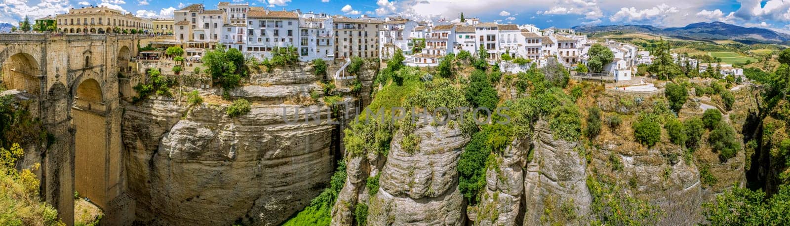Ronda Panoramic view over Puente Nuevo ("New Bridge"") The newest and largest of three bridges that span the 120-metre (390 ft)-deep chasm that carries the Guadalevín River and divides the city of Ronda, in southern Spain. Built between 1759-1793, the architect was José Martin de Aldehuela."