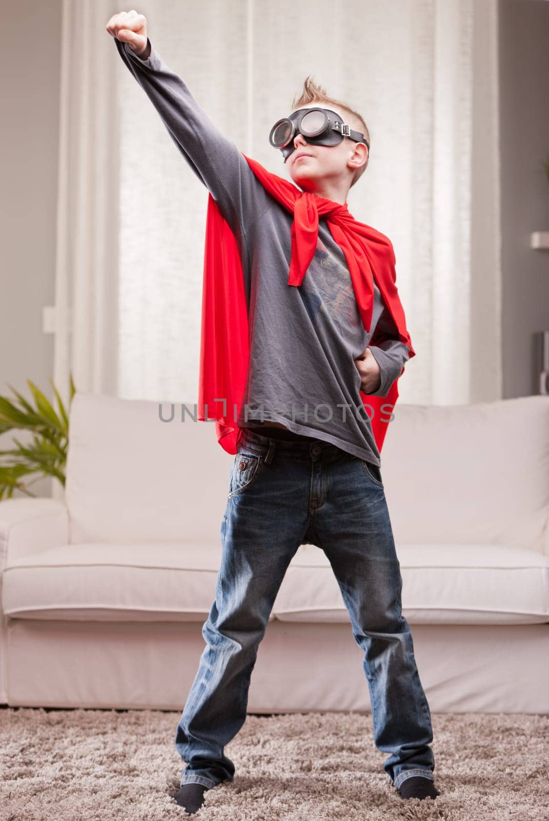 a little kid playing as a red cloak serious superhero
