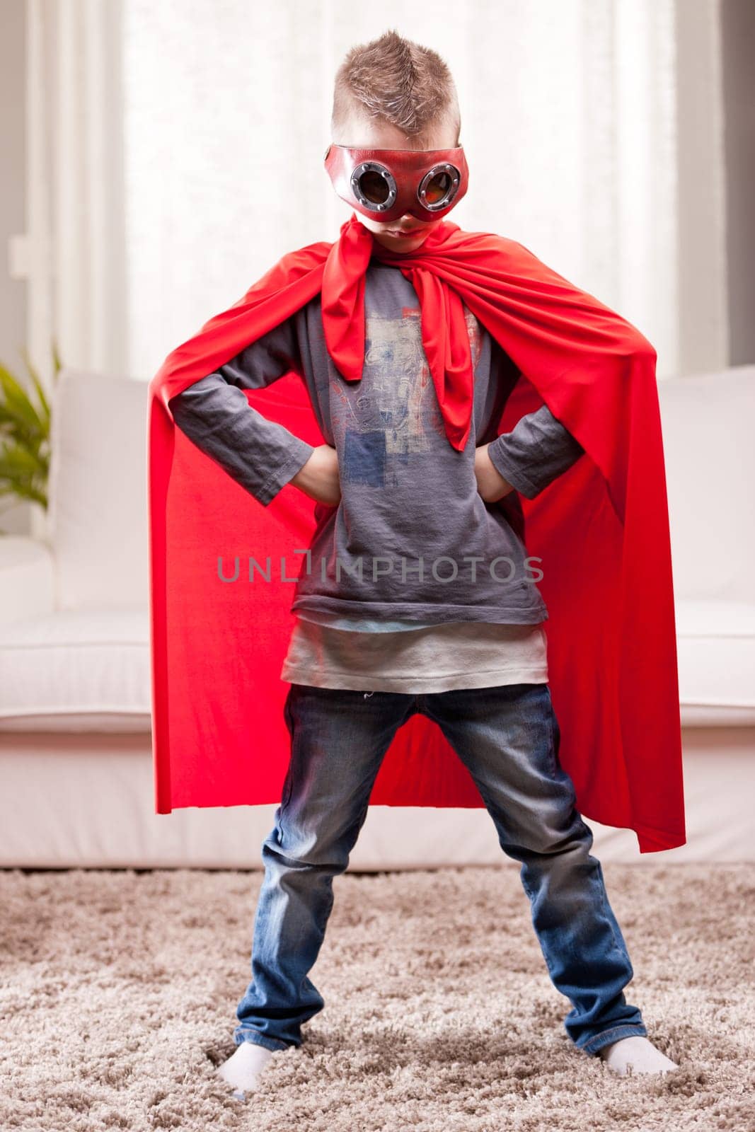 a little kid playing as a red cloak serious superhero