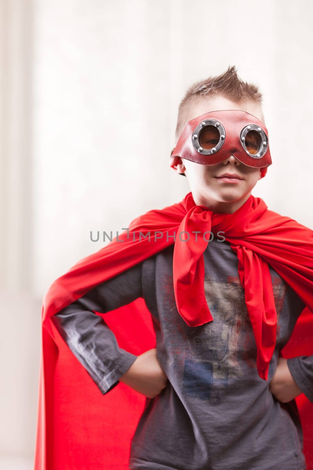 a little kid playing as a red cloak serious superhero