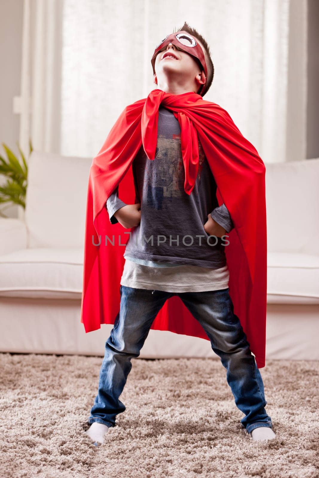 a little kid playing as a red cloak serious superhero