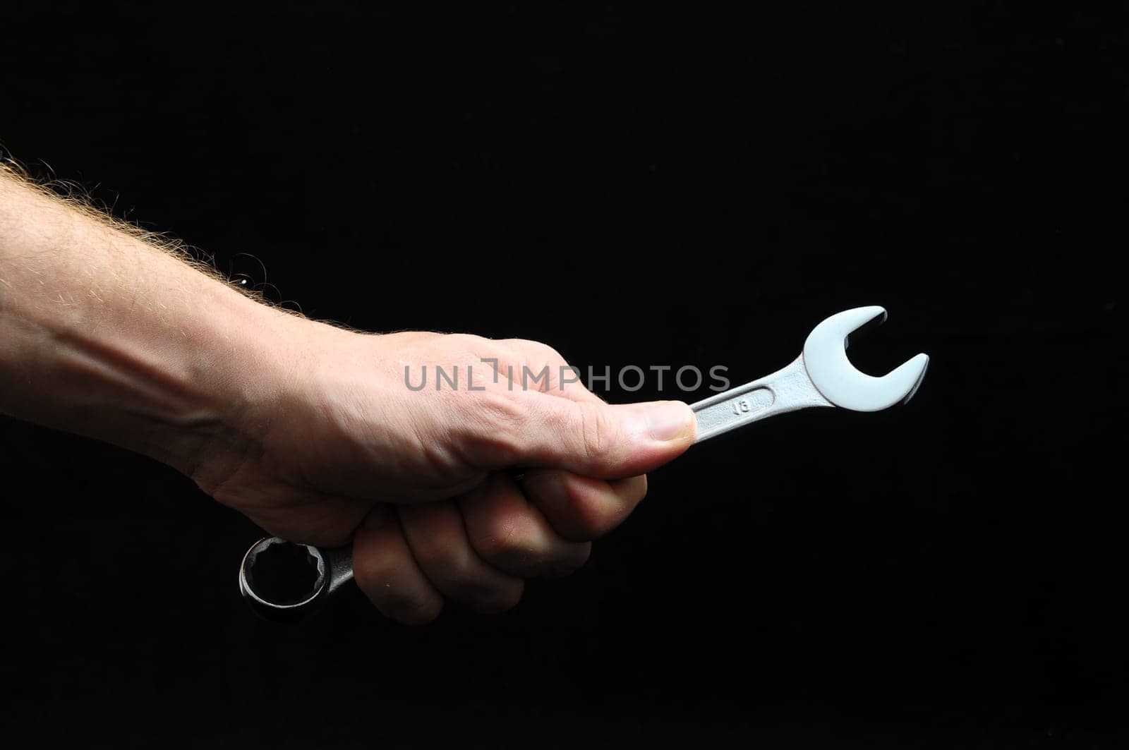 One Key Bolts and a Hand on a Black Background