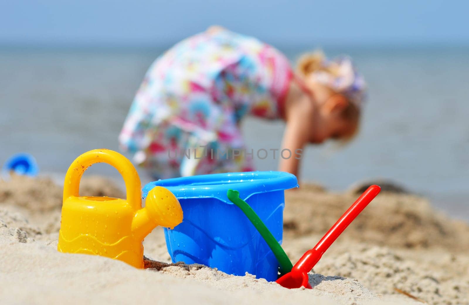 Little girl playing on the sand beach.