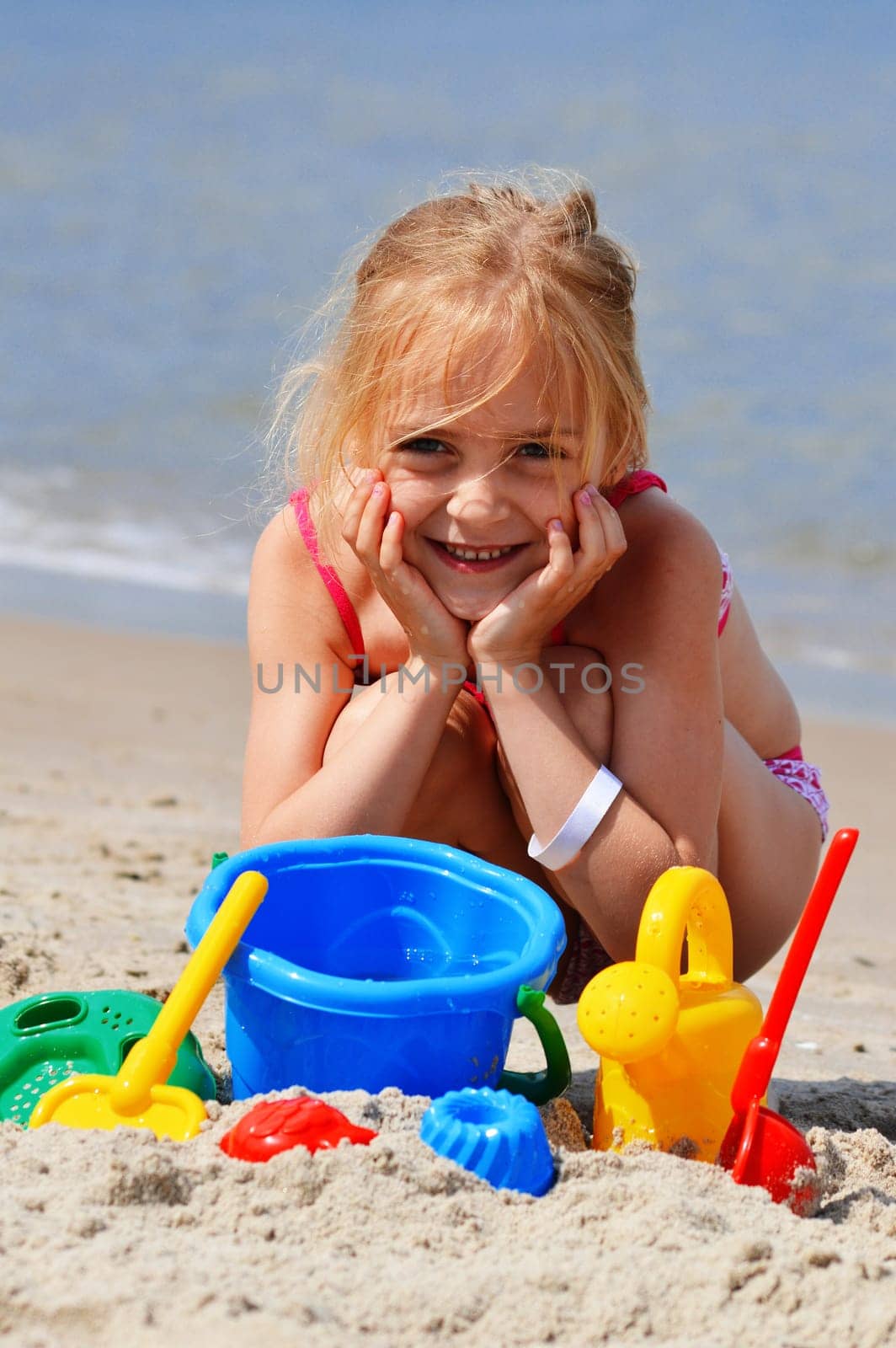 Little girl playing on the sand beach.
