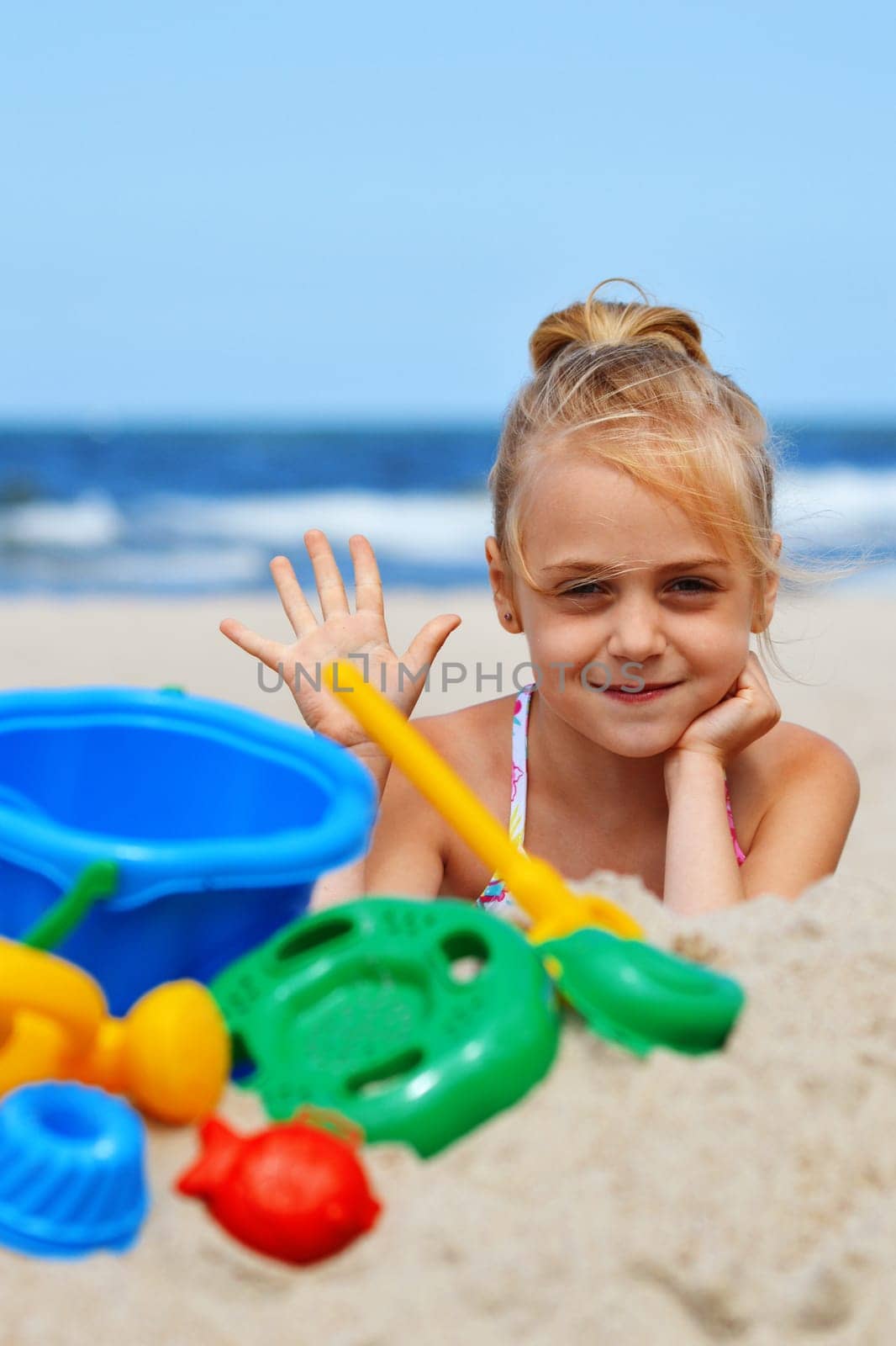 Little girl playing on the sand beach.