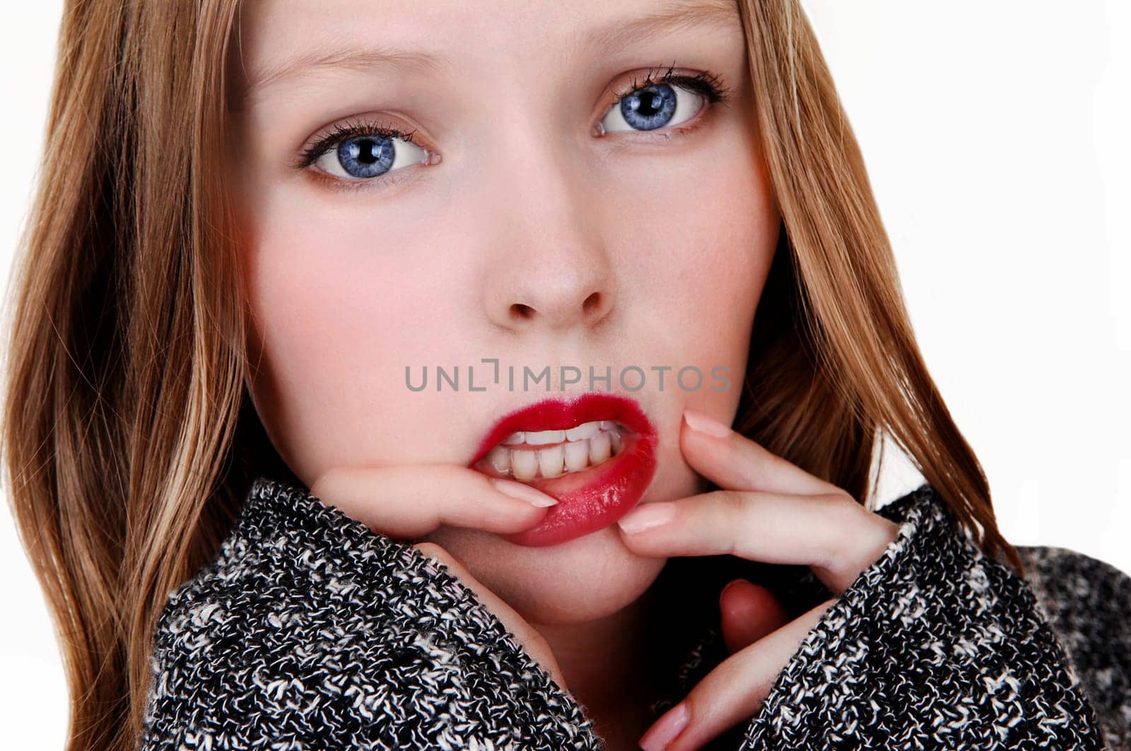 A pretty teenager's face in closeup with her finger's on her lips,.isolated for white background..