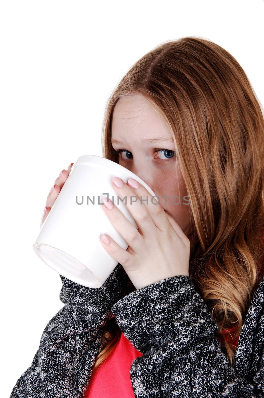 A young lovely teen girl standing isolated for white background drinking from. a big coffee mug, smiling into the camera..