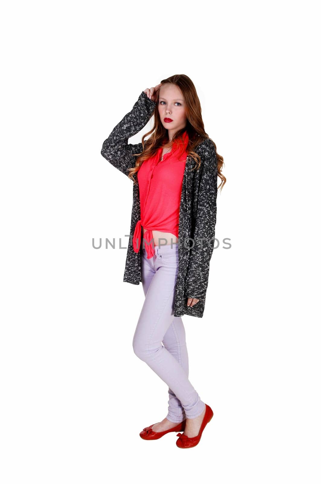 A young teen girl in a blue-grey sweater standing in the studio,.isolated for white background..