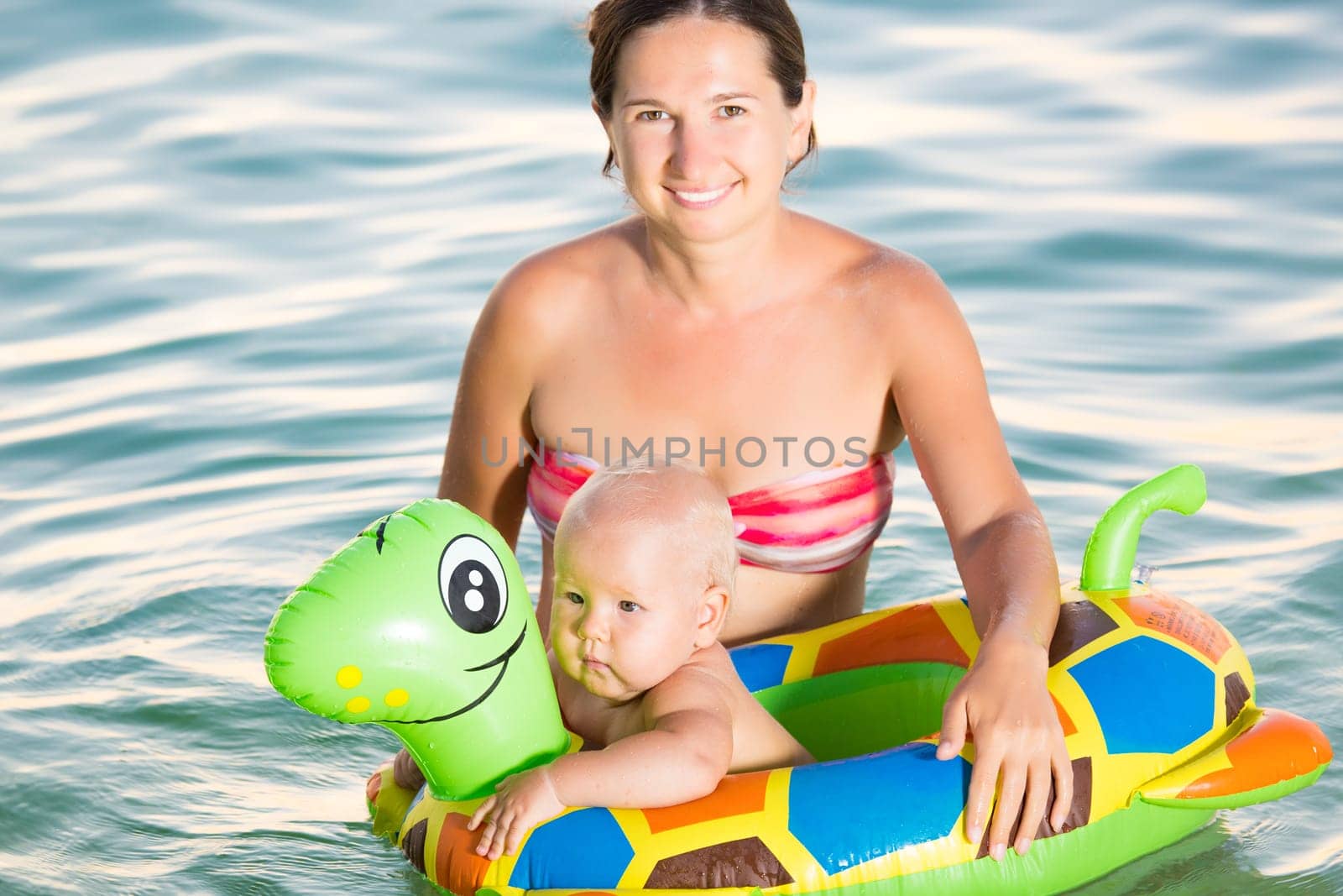 Baby and mother having fun time in the sea