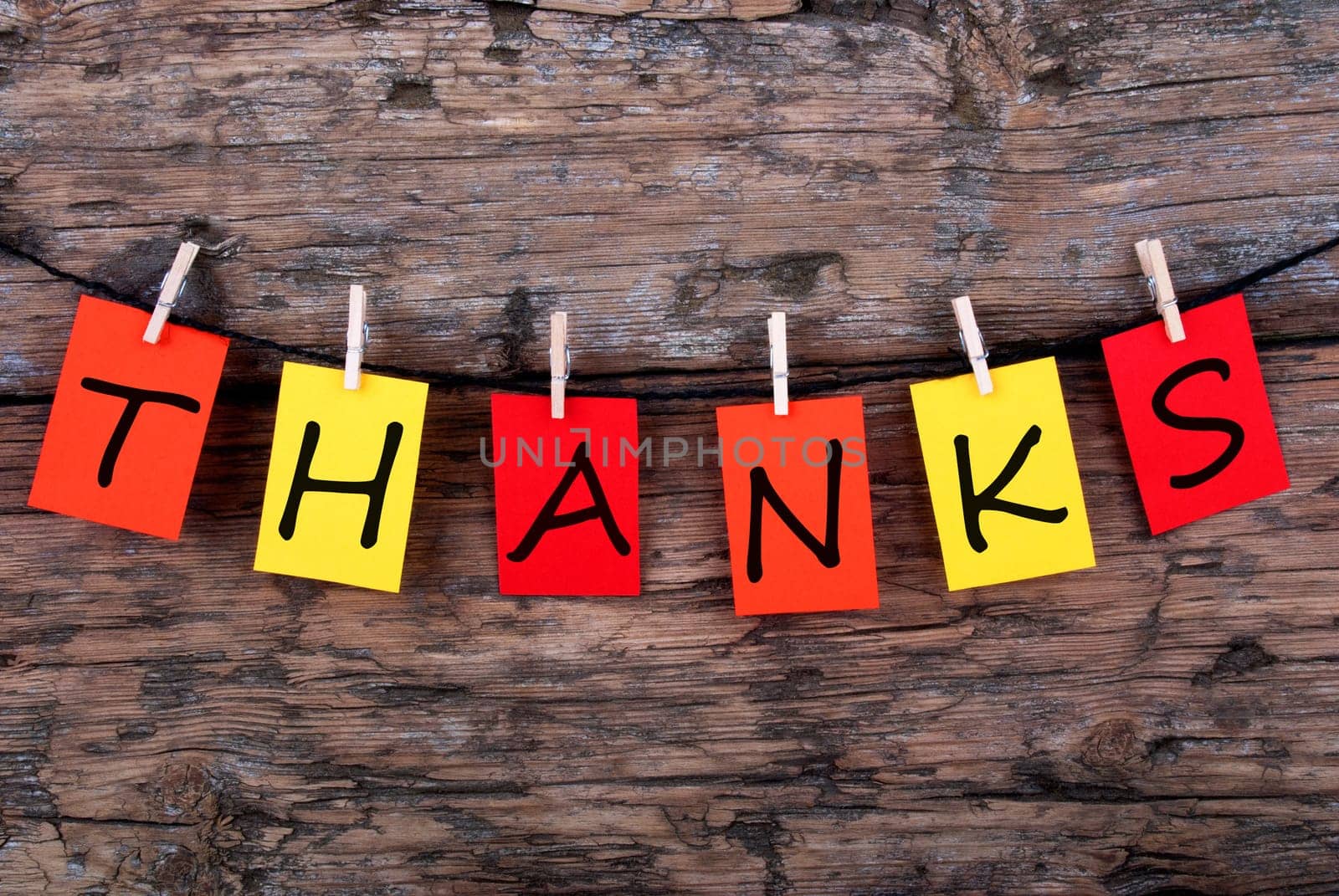 The Word Thanks on Colorful Tags on a Line on Wood