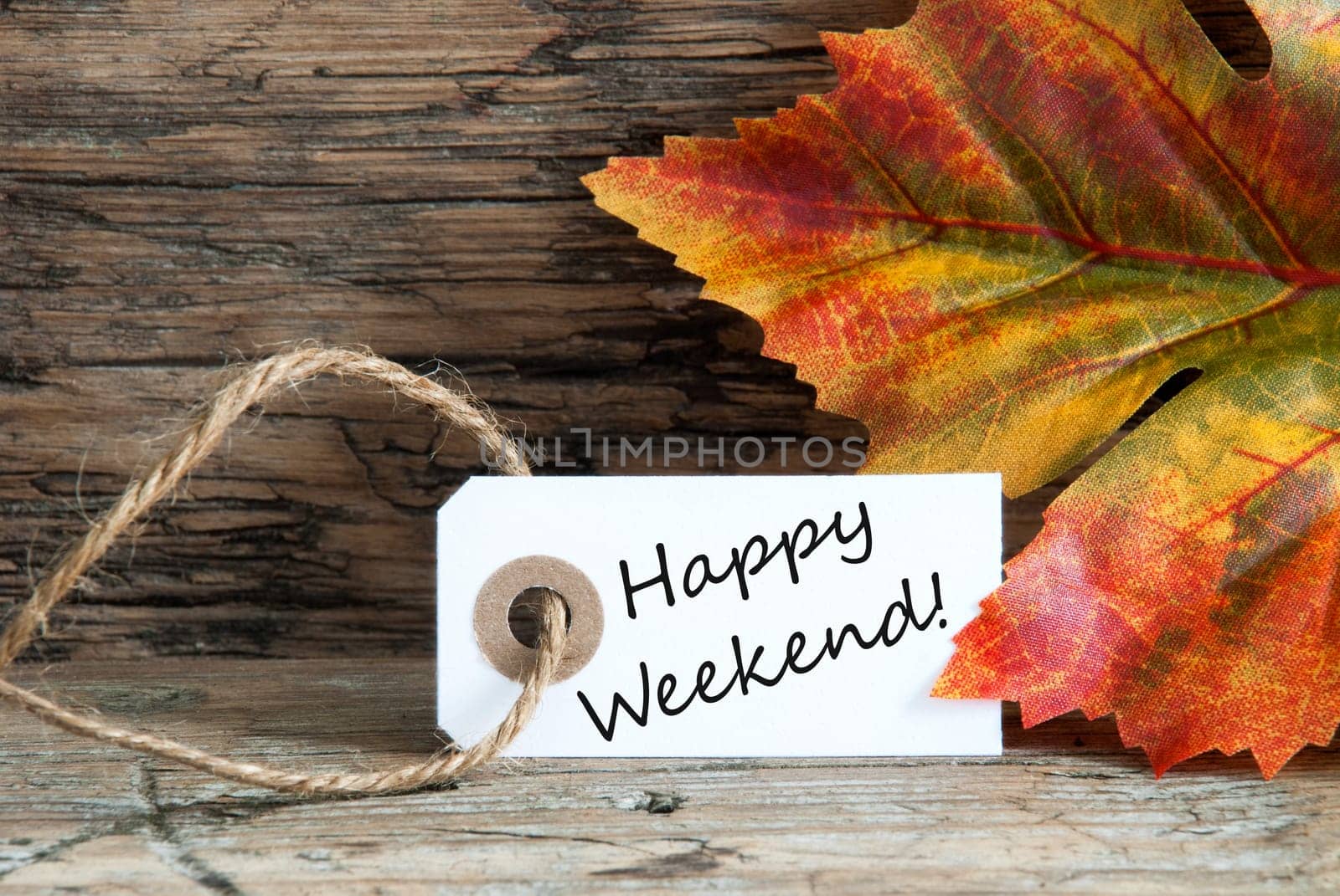Happy Weekend written on a label with Autumnal Background