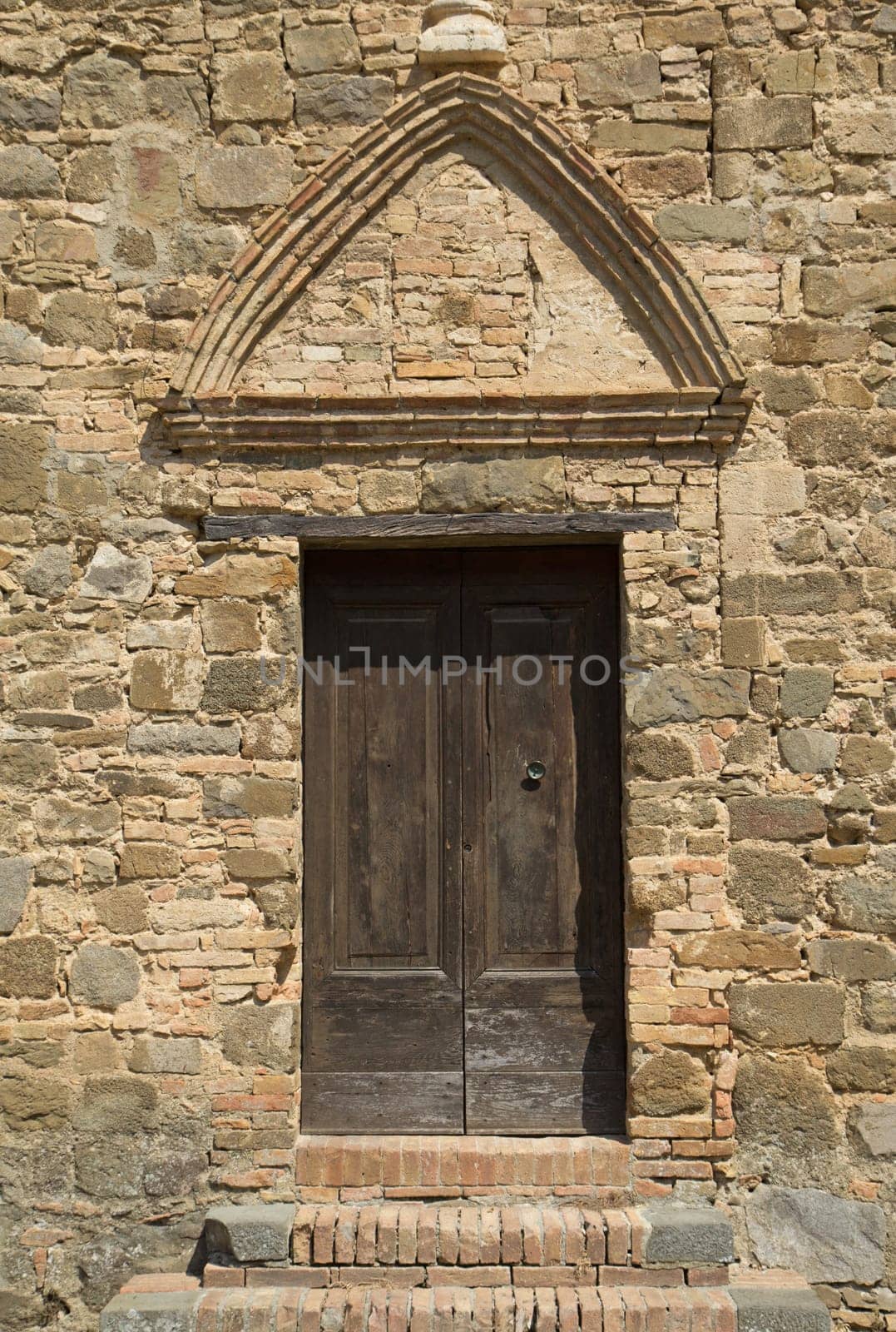Medieval wooden door. Entrance to the church. (Montalcino, Italy)