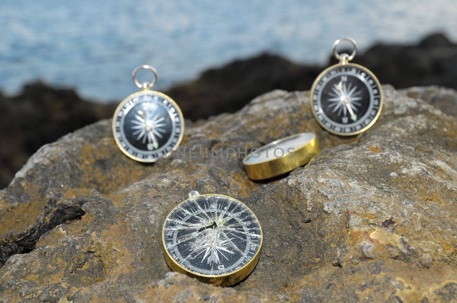 Orientation Concept - Analogic Compass Abandoned on the Rocks